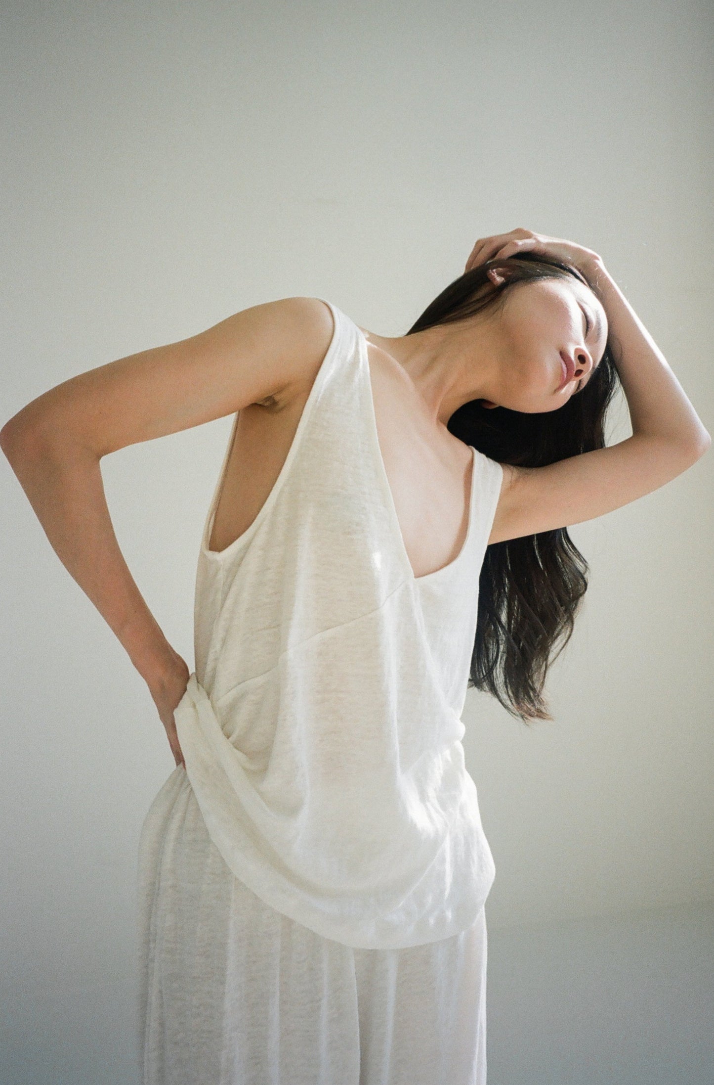 Female model wearing soft tank - ecru by Deiji Studios against plain background