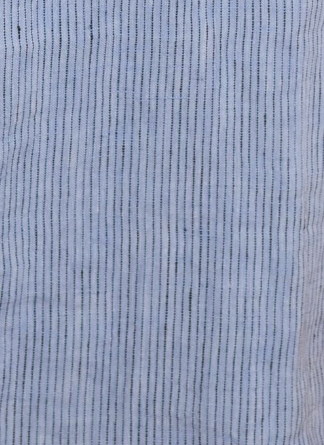 Close-up of the Smock Dress - Blue Stripe by Deiji Studios, featuring light blue fabric with thin, evenly spaced dark blue vertical stripes and a softly wrinkled texture.