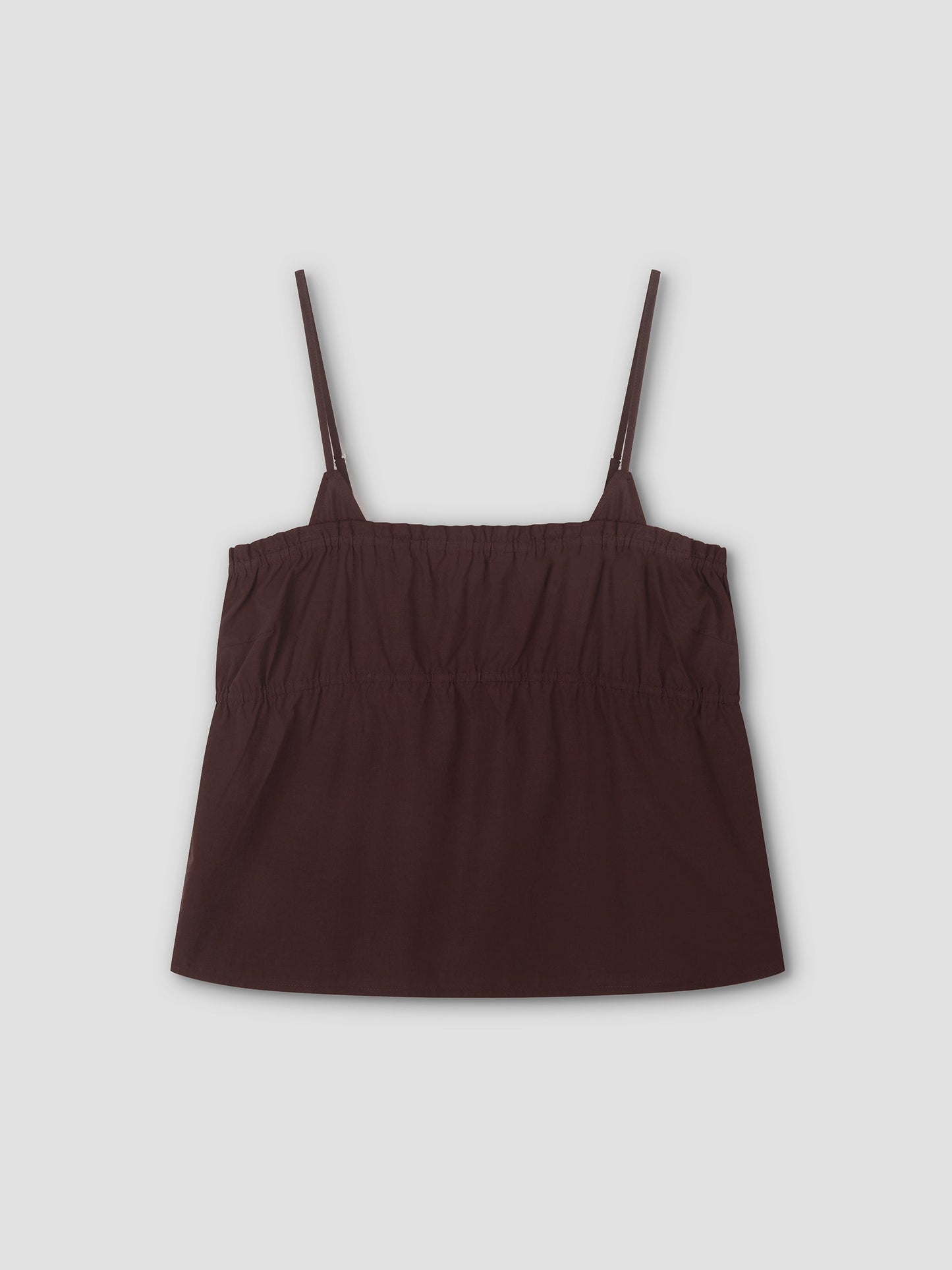The Tri Cami - Sepia is a dark brown, sleeveless cami top with thin adjustable straps and an elasticized gathered chest, offering a relaxed silhouette. Shown laid flat on a light gray background.