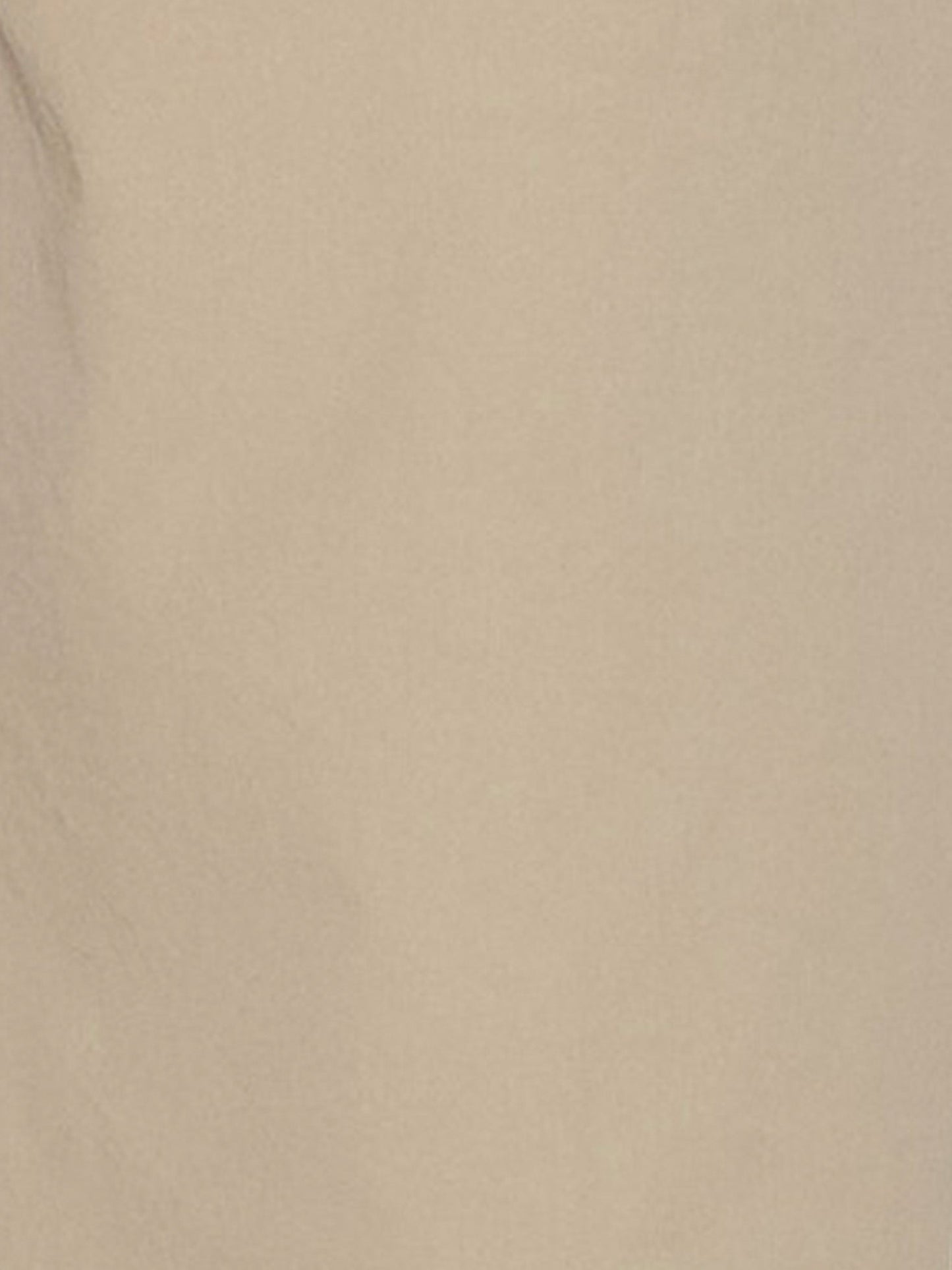 A close-up of a smooth beige surface with subtle shadows and texture, evoking the refined organic cotton featured in Deiji Studios Two Band Pant - Fawn.