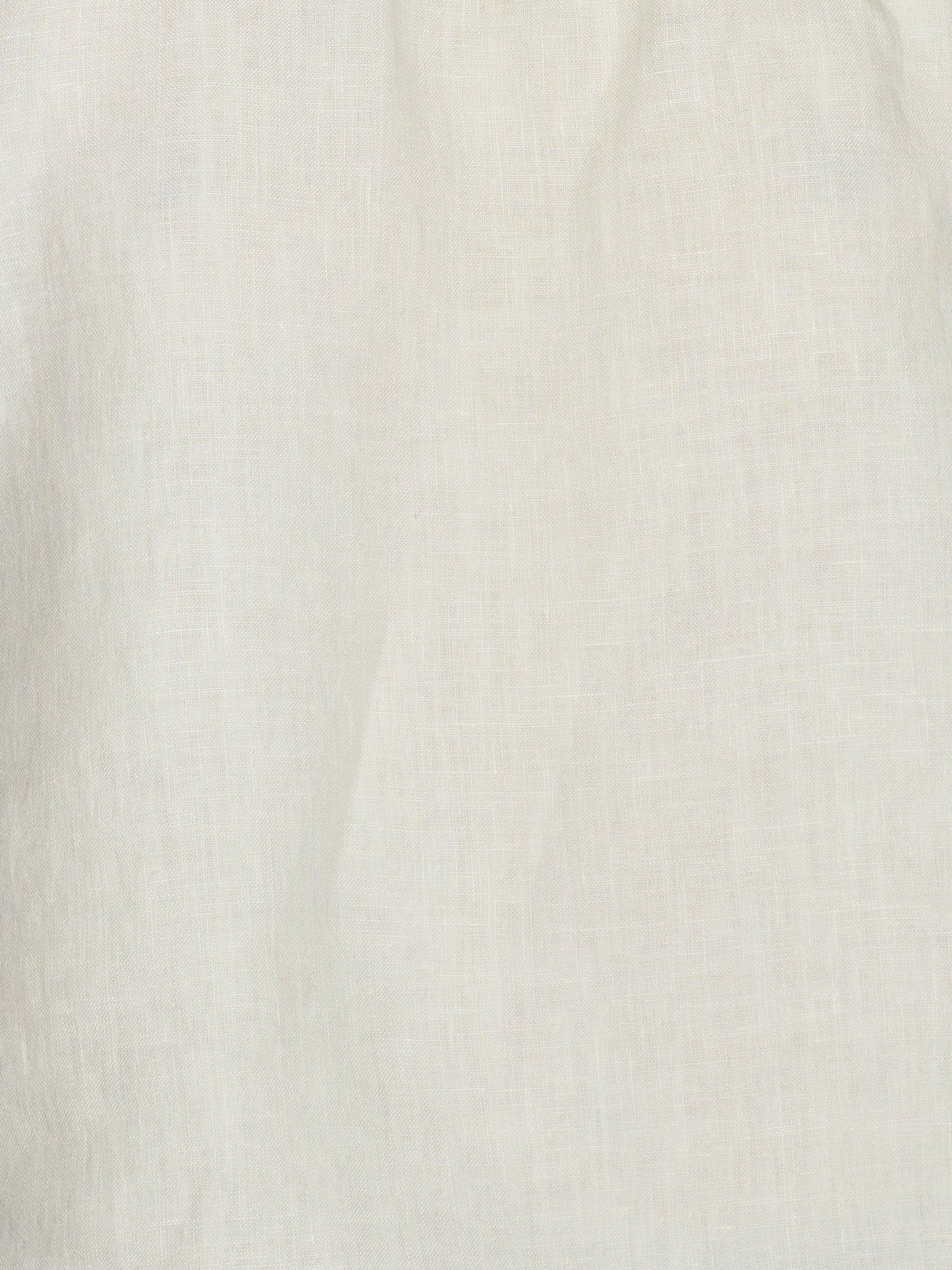 Close-up of a plain, light-colored French linen fabric with a subtle woven texture and soft folds, as used in the Linen Strap Dress - Pastel Pistachio. The material appears off-white or cream in color.