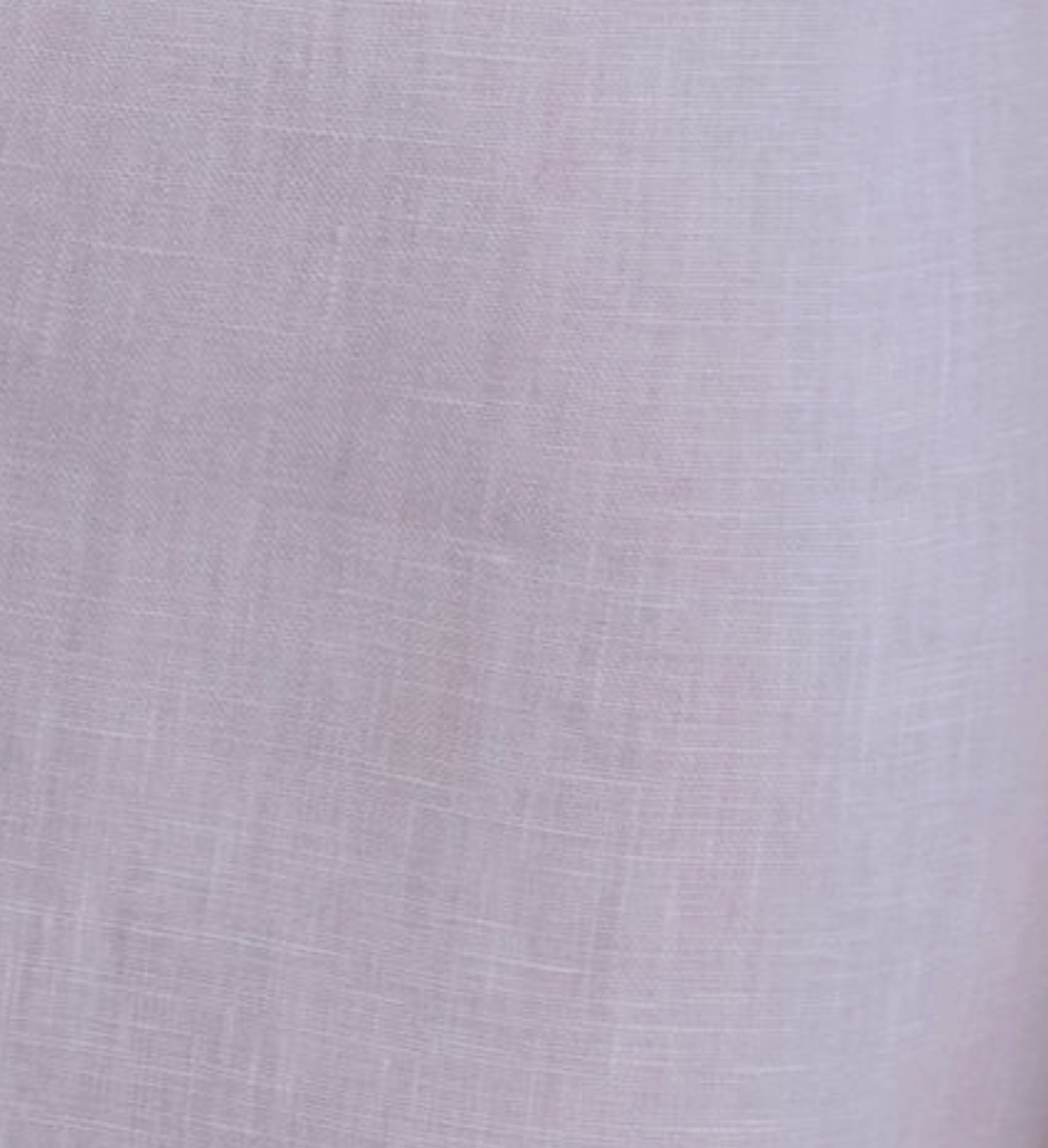A close-up of lilac fabric, similar to that used in the Lettuce Mini Dress - Lilac, showing a subtle woven texture with visible intersecting threads.