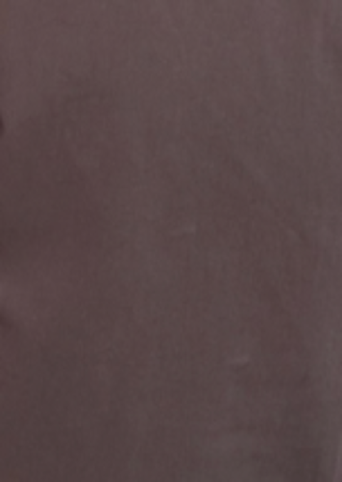 A close-up image of a solid, dark reddish-brown surface with a slightly uneven texture, reminiscent of organic cotton fabric from Deiji Studios’ Adjust Pocket Pant – Sawdust.