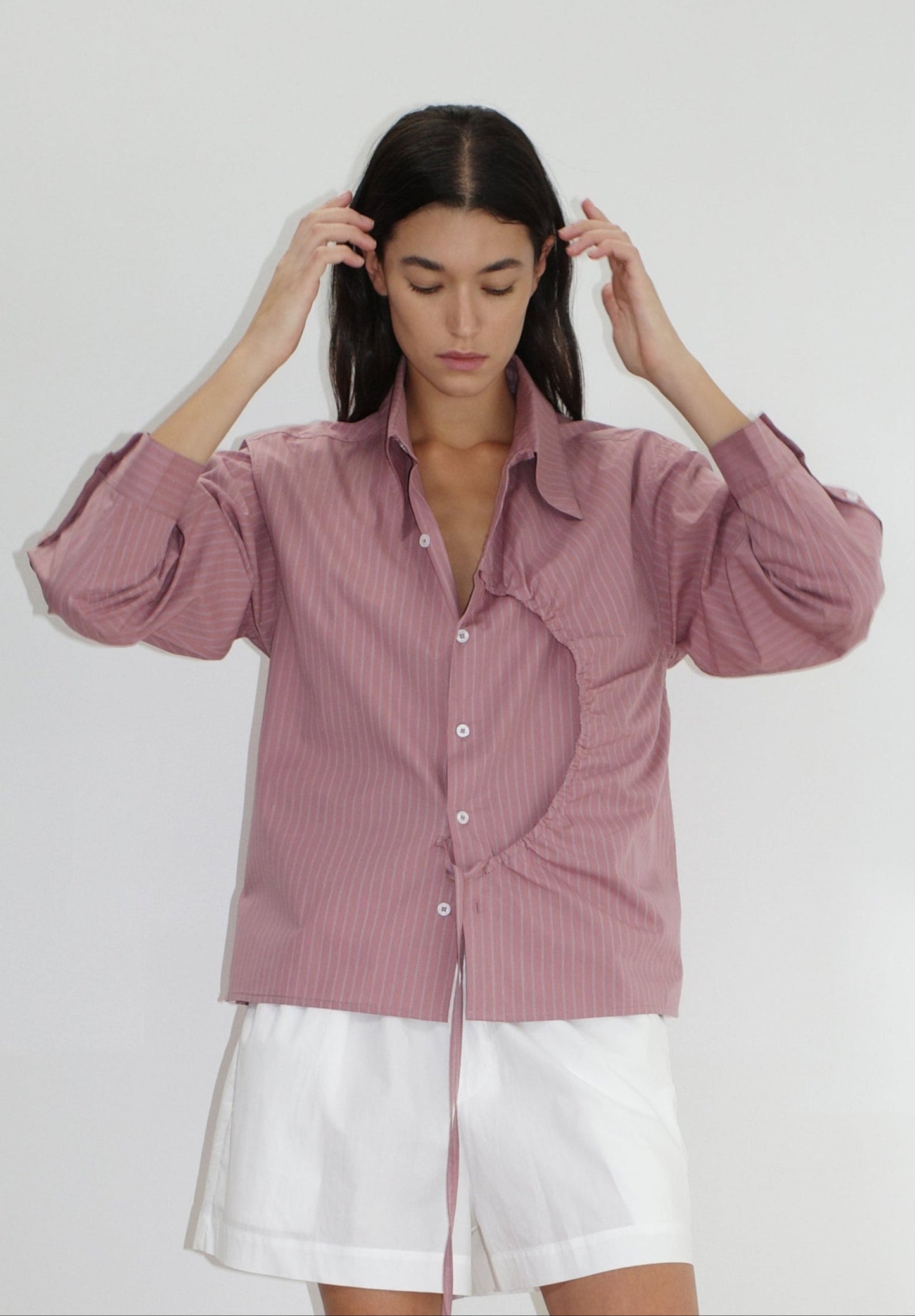 female model wears the arch tie shirt by Deiji Studios in salt stripe


a classic crisp button up shirt in a boxy fit, featuring a dropped back yoke, dropped shoulders, a classic shirting cuff with a layered arch fabric detail on front with tie


made from 100% GOTS certified organic cotton poplin

paired with a white cotton short