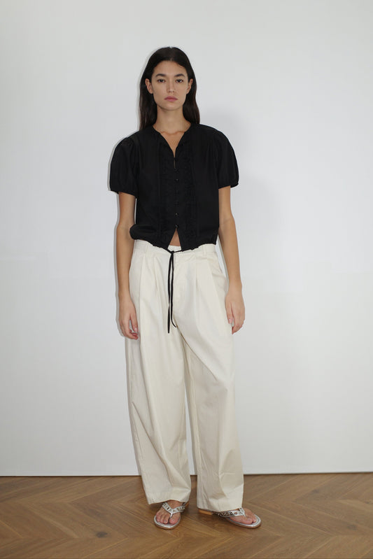 female model wears the double frill top by Deiji Studios in black


elevated everyday top features a flattering v neckline with button down front, fixed ruffle details, soft bloussant sleeve and gathered elastic cuffs


made from 100% GOTS certified organic cotton poplin

paired with a white cotton trouser