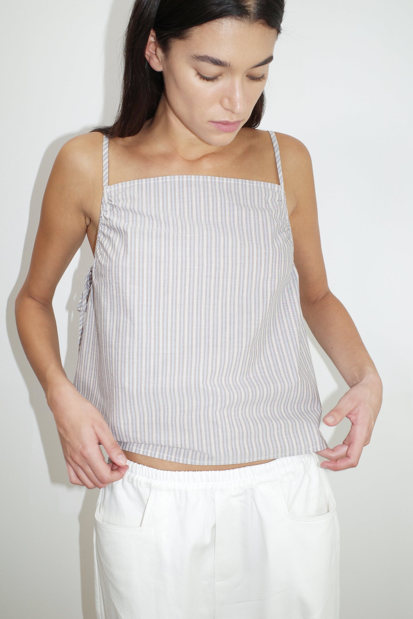 female model wears the gathered strap top by Deiji Studios in seas stripe


a lightweight top featuring fixed gathered armholes and right hand side armhole keyhole and ties


made from 100% organic cotton poplin

paired with a white cotton trouser