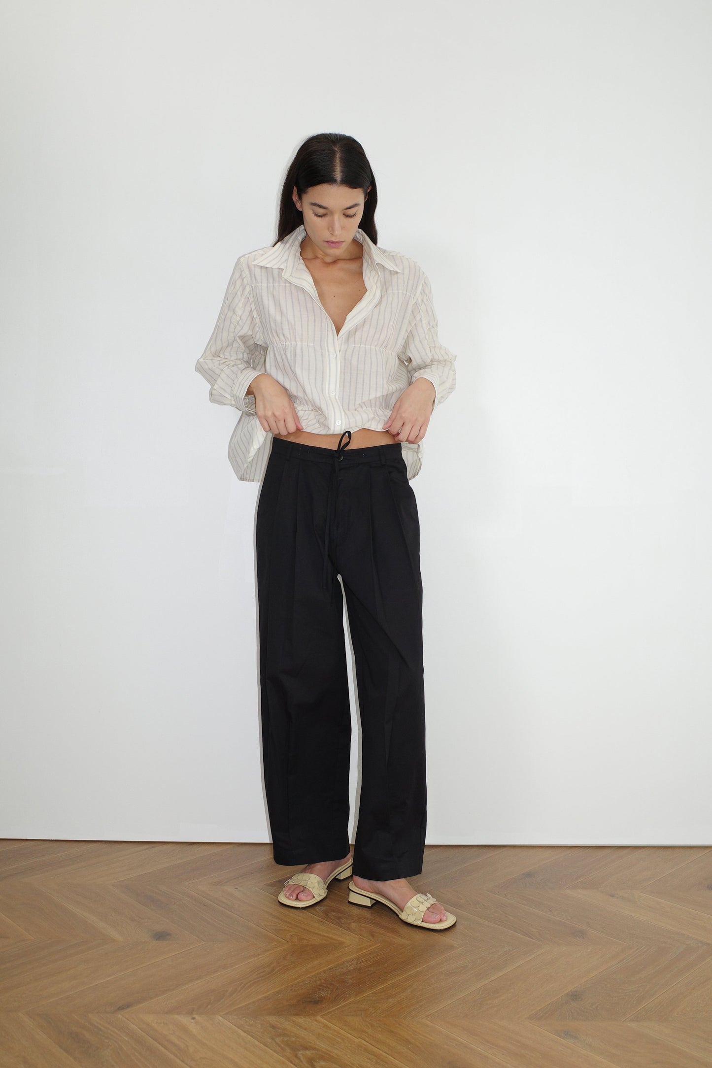 female model wears the gathered shirt by Deiji Studios in raquette stripe


a classic button up style shirt featuring a butter base with mixed blue stripe, elasticated gathered seams and dropped shoulder for a relaxed fit


made from 100% GOTS organic cotton

paired with a black pant