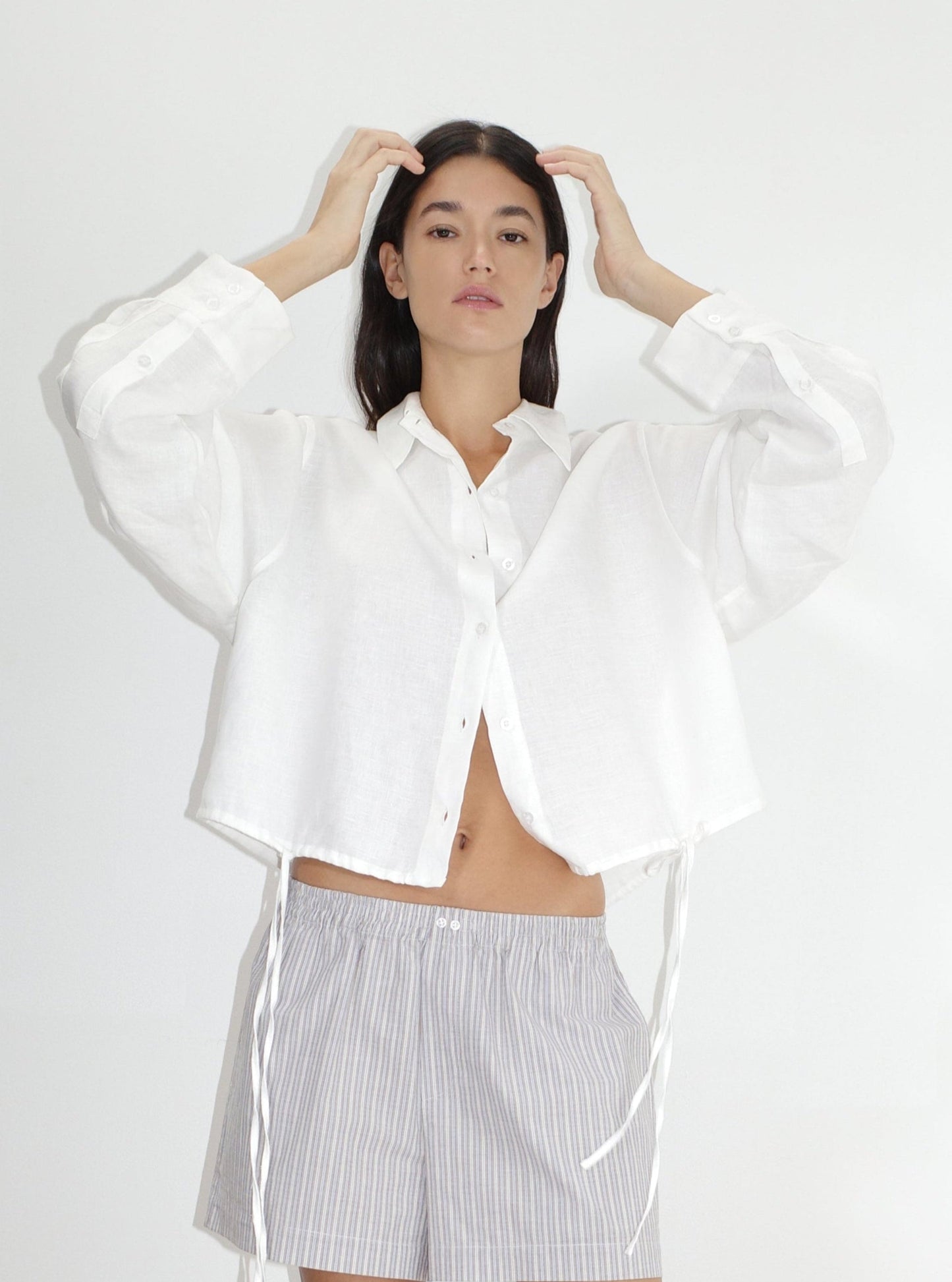 female model wears the hem shirt by Deiji Studios in white


a classic button up style shirt featuring a drawcord tie channel at bottom hem, dropped back yoke and dropped shoulder for a relaxed fit


made from 100% OEKO-TEX 100 certified and EU certified stone washed french linen

paired with boxer short in seas stripe