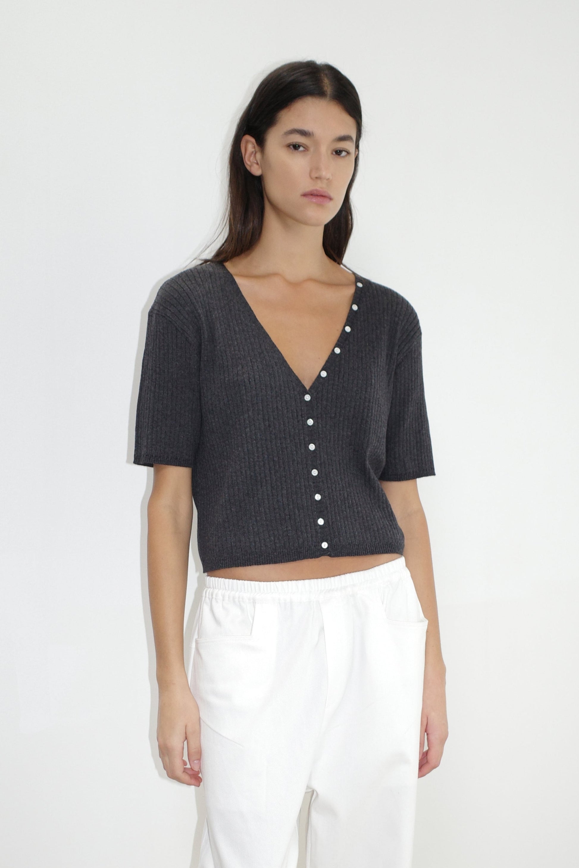 female model wears the one piece tee by Deiji Studios in coal


a fully fashioned ribbed knit features a flattering deep v neckline, mid length sleeve and button front design feature in a relaxed fit


made from 95% BCI cotton and 5% cashmere

paired with a white cotton trouser