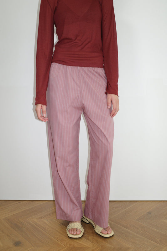 female model wears the ease trouser by Deiji Studios in salt stripe


the ankle length pant features a soft minimal elastic waist with side seam pockets in a straight leg


can be worn at home, in bed, or out


made from 100% GOTS certified organic cotton poplin

paired with a sheer long sleeve knit in crimson red