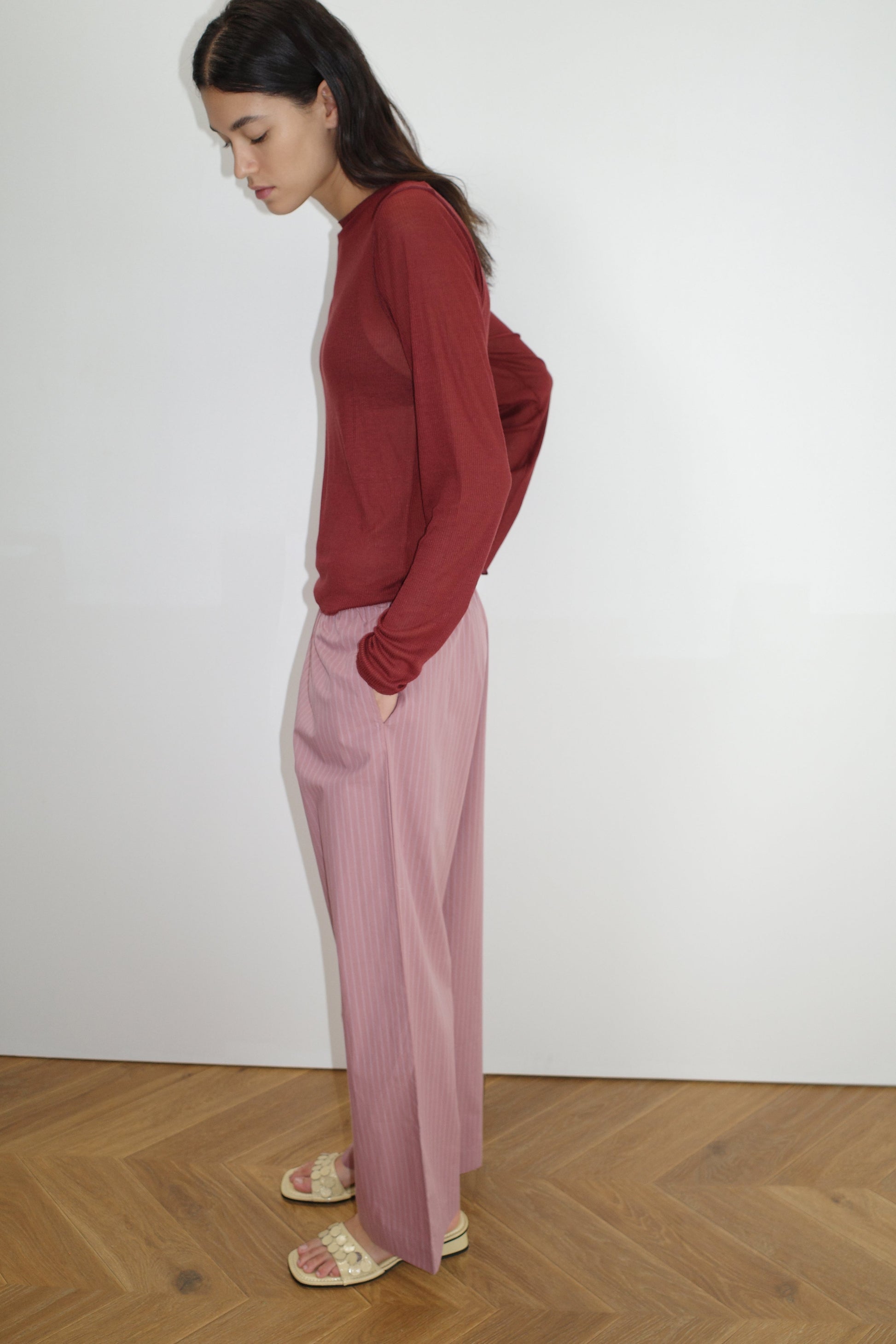 female model wears the ease trouser by Deiji Studios in salt stripe


the ankle length pant features a soft minimal elastic waist with side seam pockets in a straight leg


can be worn at home, in bed, or out


made from 100% GOTS certified organic cotton poplin

paired with a sheer long sleeve knit in crimson red