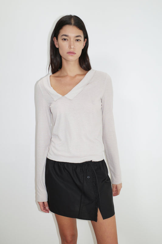 female model wears the cross collar top by Deiji Studios in shell


a sheer fine knit long sleeved top with asymmetric collared neckline, featuring baby locked finishes and a relaxed fit


made from a responsible blend of 85% Recycled Polyester and 15% Viscose

paired with a black cotton skirt