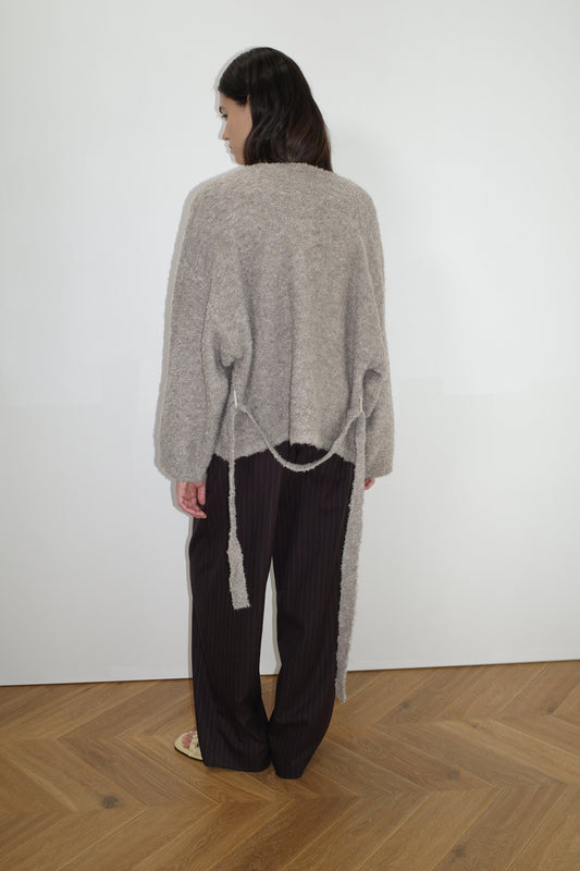 female model wears the pod knit by Deiji Studios in cloud grey


a relaxed and textured knit features a round shaped neckline with press stud front closure, removable self tie belt with long sleeves and high back neckline


made from a sustainable knit blend of 12% RWS certified wool, 30% recycled acrylic, 64% recycled polyester and 4% spandex

paired with a pinstripe wool pant