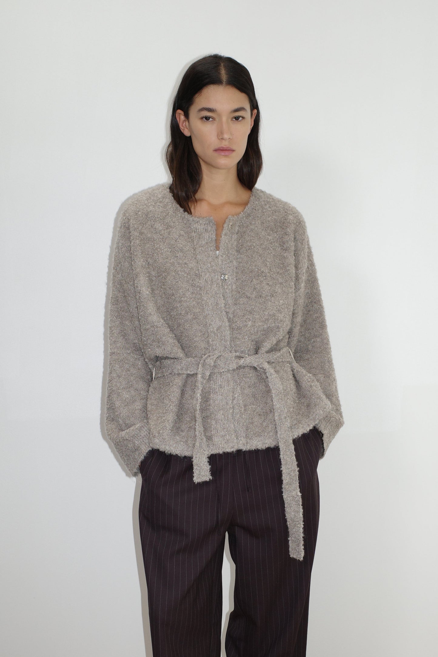 female model wears the pod knit by Deiji Studios in cloud grey


a relaxed and textured knit features a round shaped neckline with press stud front closure, removable self tie belt with long sleeves and high back neckline


made from a sustainable knit blend of 12% RWS certified wool, 30% recycled acrylic, 64% recycled polyester and 4% spandex

paired with a pinstripe wool pant