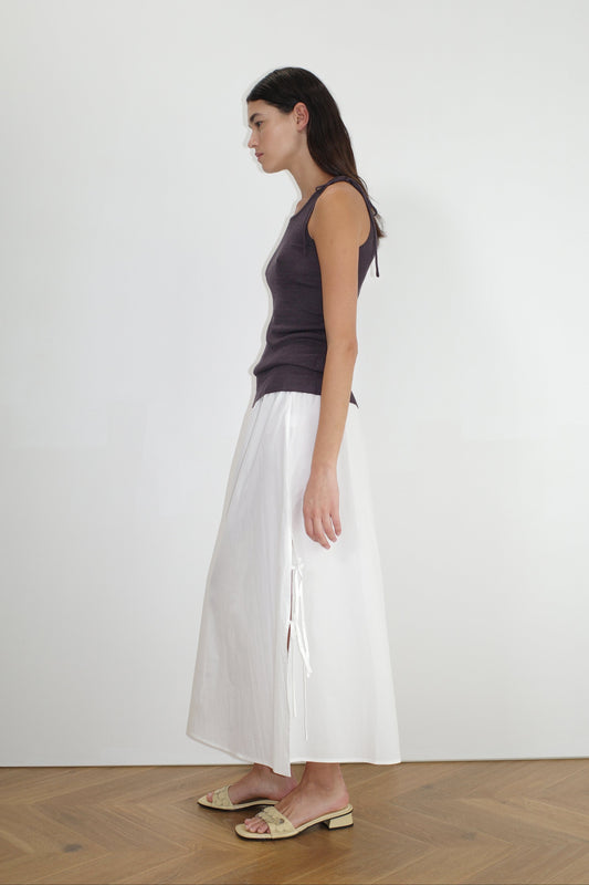 female model wears the split tie skirt by Deiji Studios in white


a mid length, airy skirt designed to sit mid-rise with a soft gathered elastic waist and split side featuring two ties


made from 100% GOTS certified organic cotton poplin

paired with a knit tank in eggplant