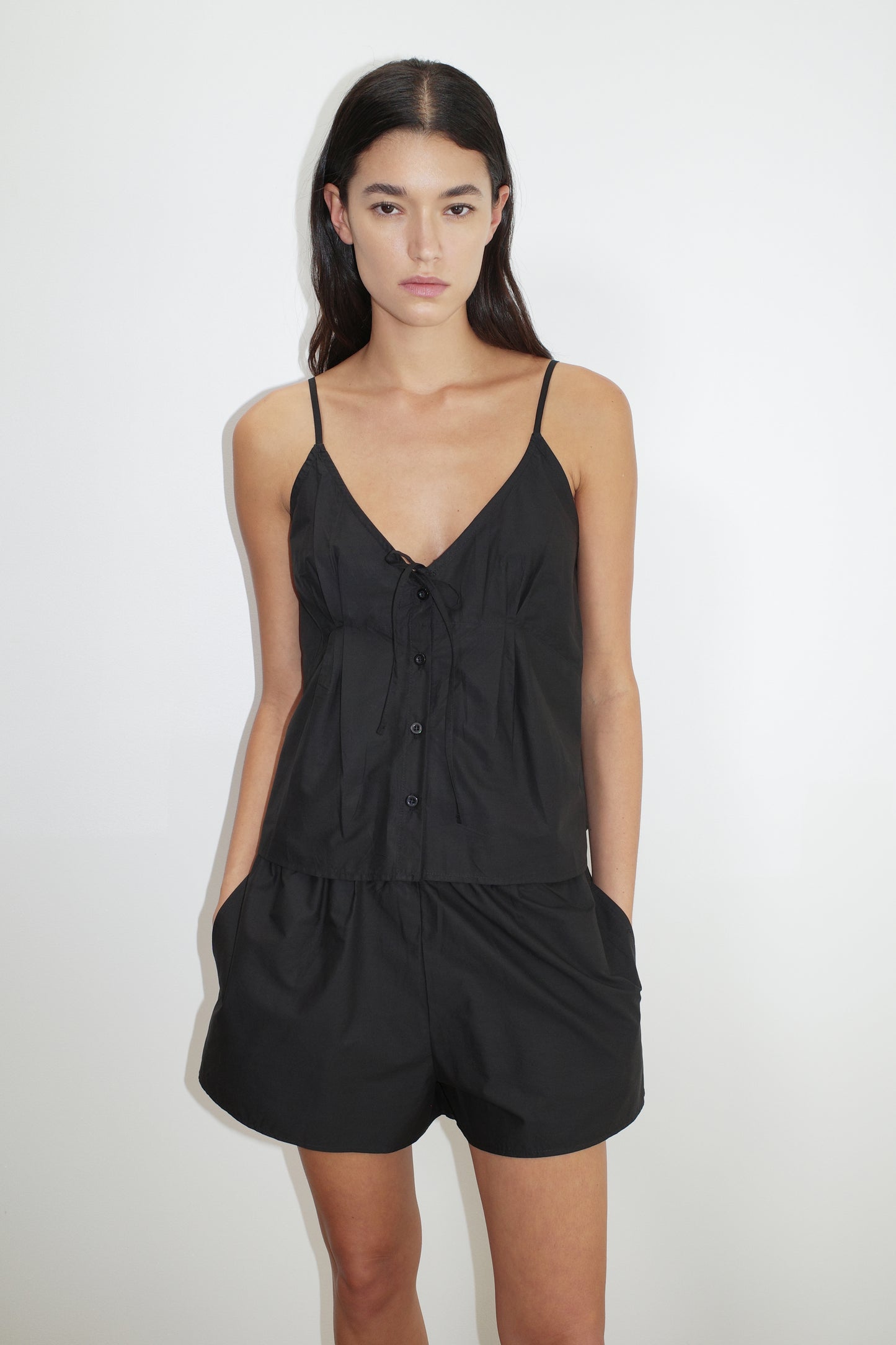 female model wears the placket short set by Deiji Studios in black


a lightweight everyday top features a flattering v neckline, button down front, side fold pleat detail at bust with a self-fabric tie pairs back with an easy pull on short, featuring a soft elastic waist and side seam pockets to wear as a set or separately


made from 100% organic cotton poplin