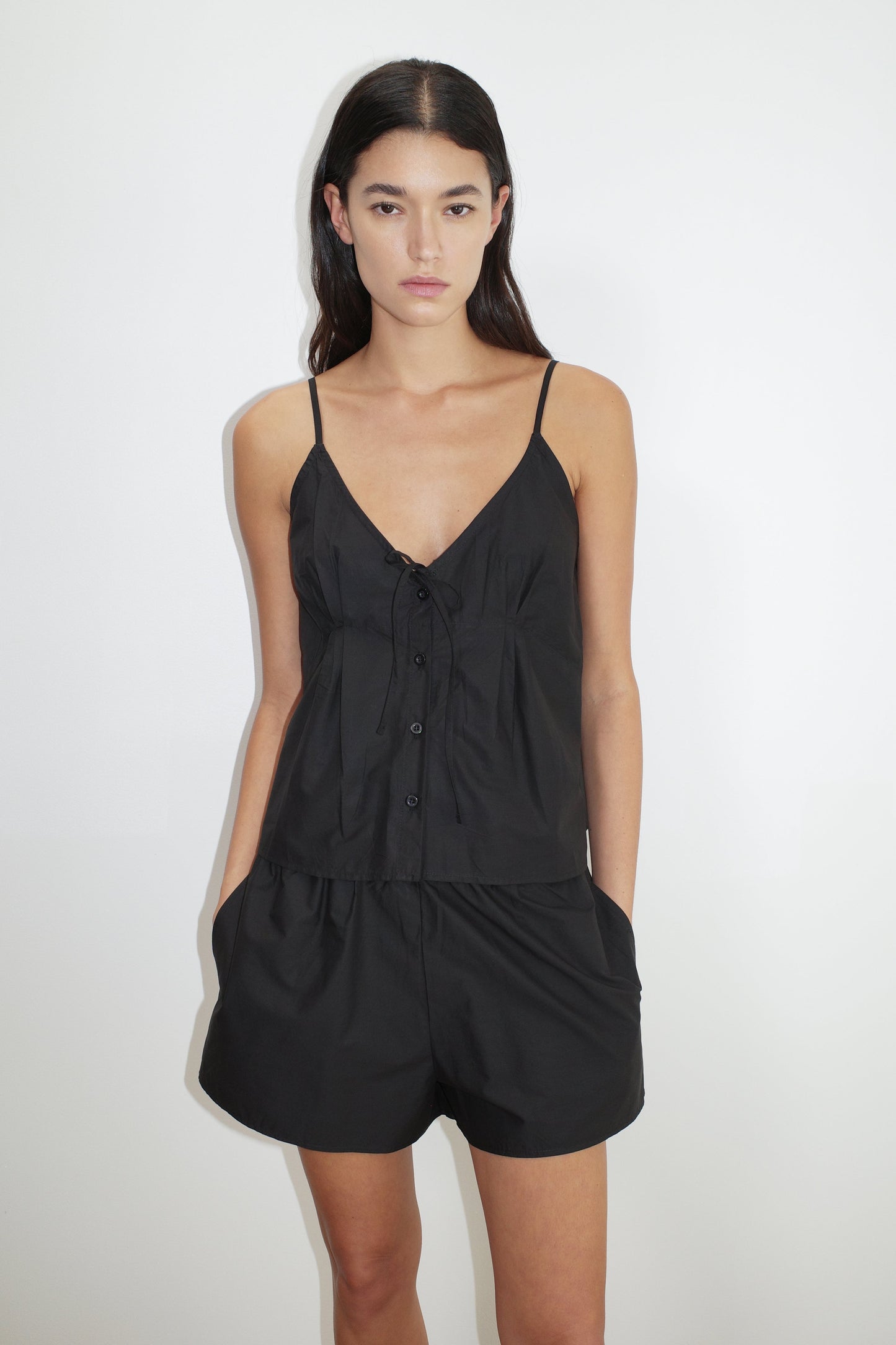 female model wears the placket short set by Deiji Studios in black


a lightweight everyday top features a flattering v neckline, button down front, side fold pleat detail at bust with a self-fabric tie pairs back with an easy pull on short, featuring a soft elastic waist and side seam pockets to wear as a set or separately


made from 100% organic cotton poplin