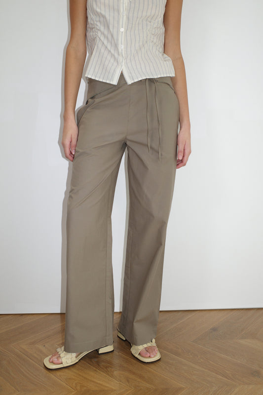 female model wears the belted pant by Deiji Studios in clay


mid-rise loose-leg pant with attached tie-front belt detail, babylock hem, and relaxed fit. features concealed zip closure and side pockets


made from 100% organic cotton

paired with a striped singlet top