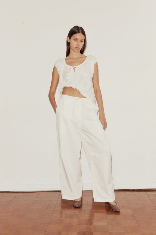 Female model wearing Bartack Pant - Snow - by Deiji Studios against plain background