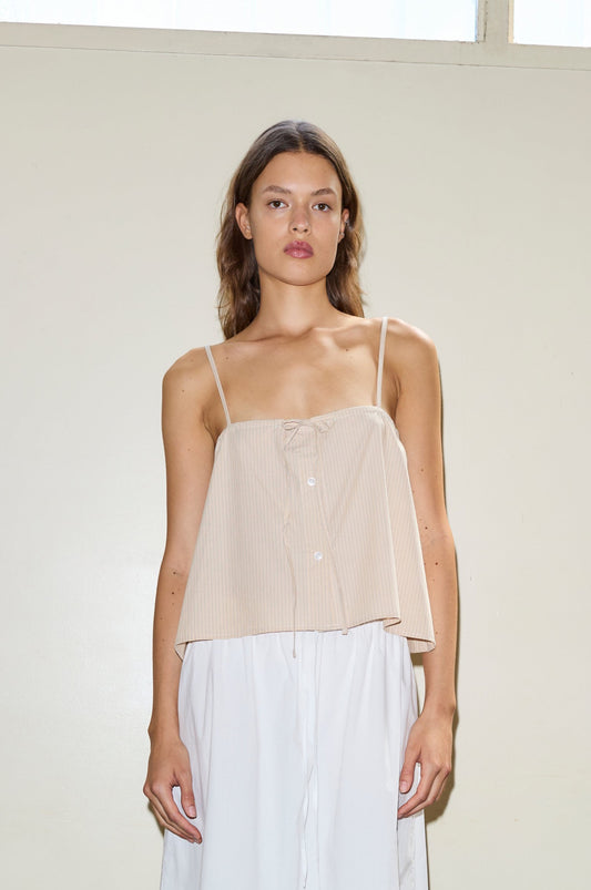 Female model wearing The Placket Strap Top - Sand Stripe by Deiji Studios against plain background