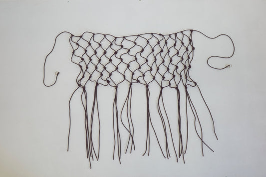 A handwoven black macramé belt made from recycled polyester, featuring loose ends and fringes, displayed flat on a white background.