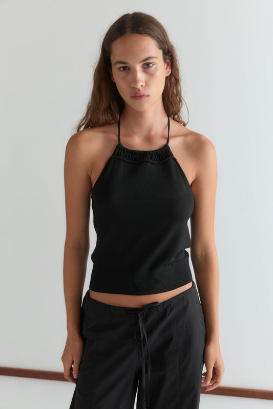 A woman with long brown hair models the Drawcord Knit Top and black drawstring pants, standing against a plain white background and looking directly at the camera with a neutral expression.