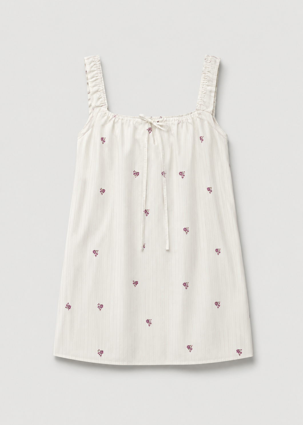 The Bow Dress - Floral Stripe by Deiji Studios, a white sleeveless mini dress with ruffled straps, a tie bow at the gathered neckline, and small purple floral prints, displayed flat against a plain light background.