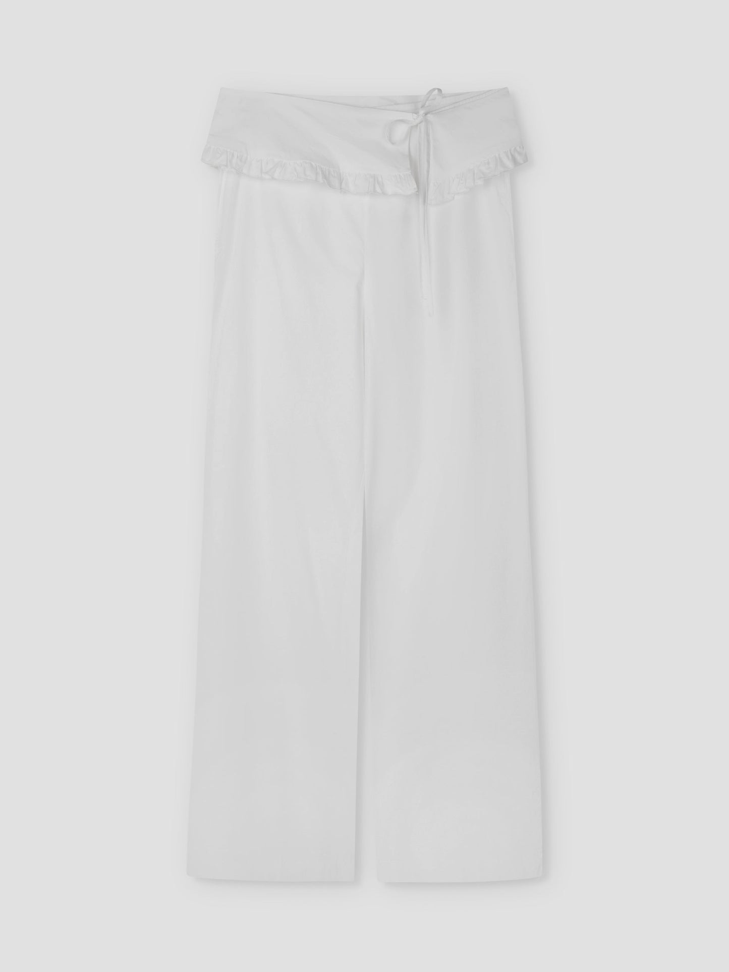 The Flounce Belt Pant - White features a wide-leg silhouette, foldover ruffle-trim waistband, and delicate drawstring tie, shown flat on a light grey background. Inspired by Deiji Studios’ signature relaxed style.