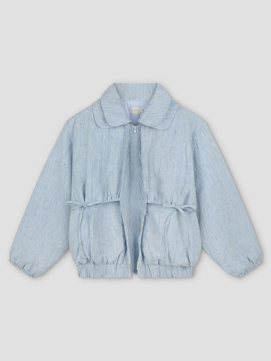 The Double Layered Jacket - Blue Stripe is a light blue bomber-style children's jacket with subtle vertical stripes, front zipper, elasticated cuffs and hem, and gathered waist, shown against a light gray background.