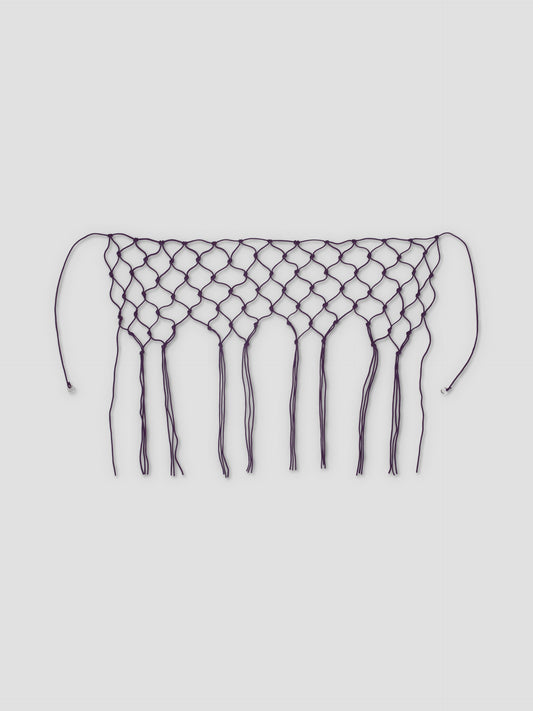 The Macrame Belt - Burgundy features a netted, diamond pattern with long fringe and two strings at each end, crafted from recycled polyester and shown on a white background.