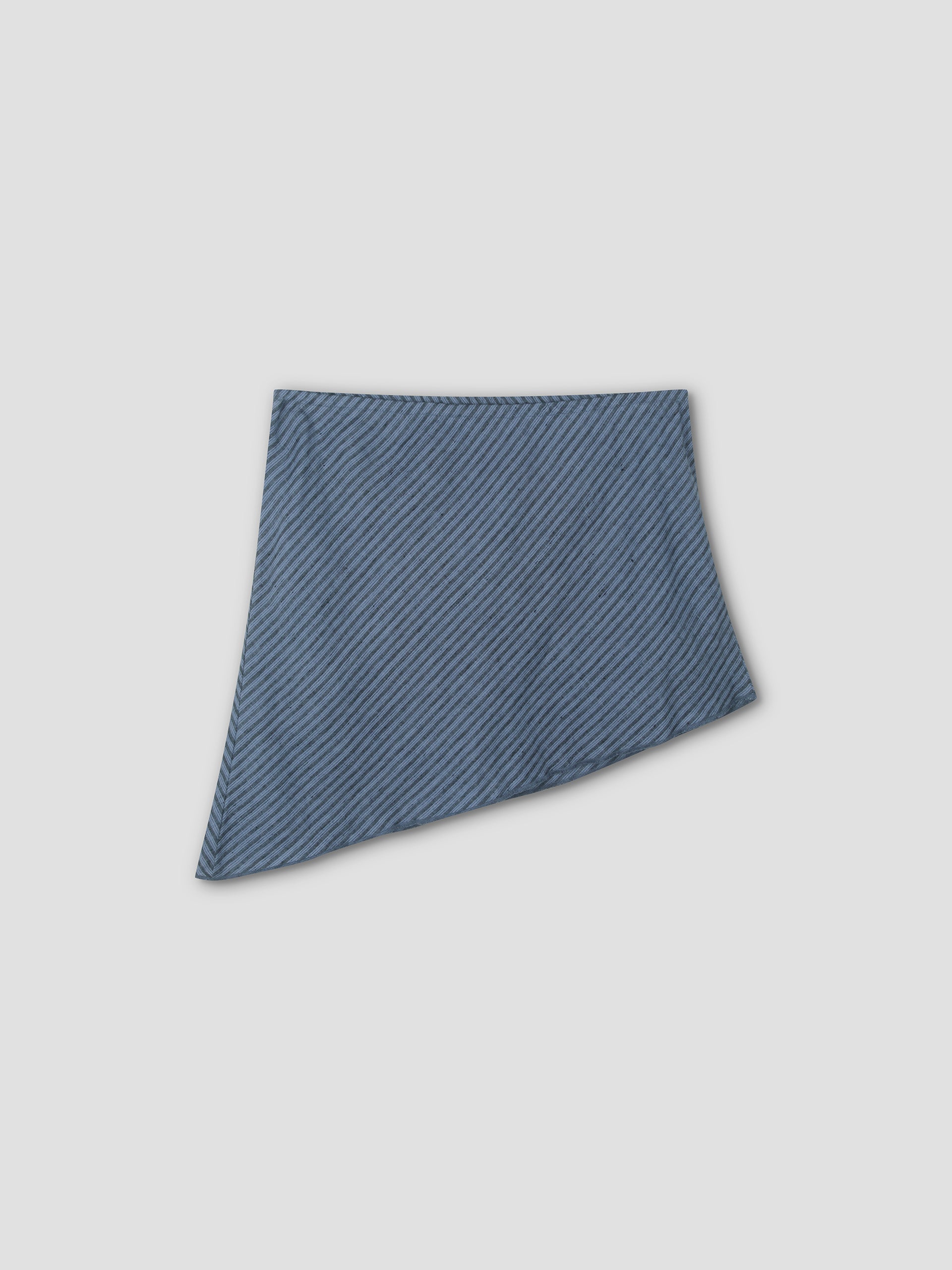 The Line Top - Azure Stripe features thin diagonal stripes and an asymmetric hem, shown on a light gray background. Style it easily with your favorite bottoms for a chic look.