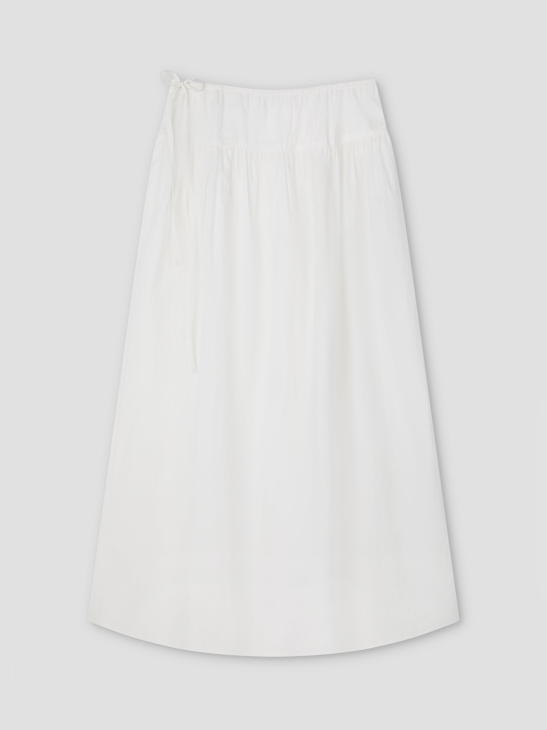 The Maxi Skirt - White Texture by Deiji Studios is a plain A-line maxi skirt with an elastic waistband and drawstring tie, shown laid flat on a light gray background.