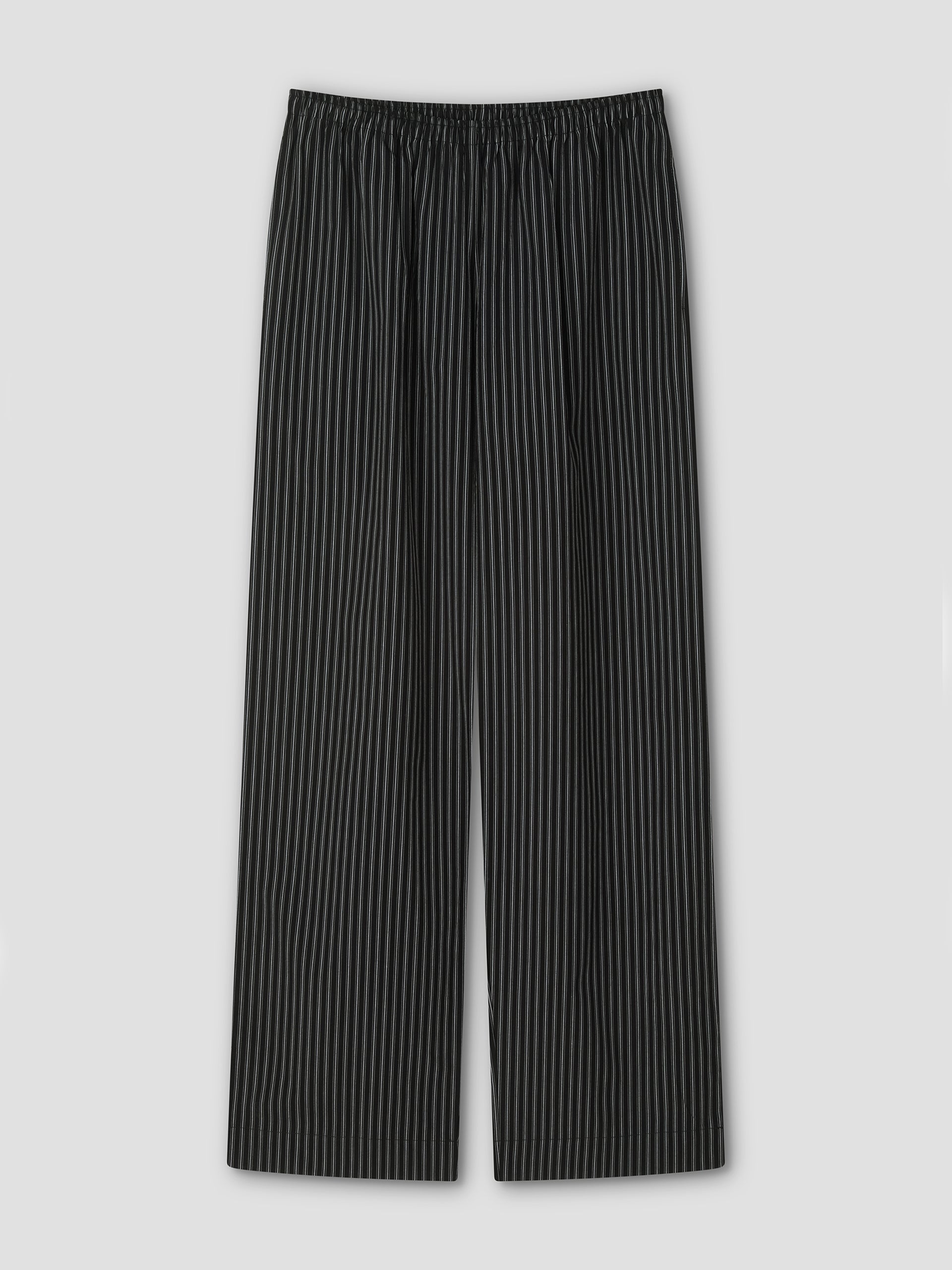 The Ease Trouser - Mono Stripe by Deiji Studios features black ankle-length design with thin white vertical pinstripes, an elastic waistband, and wide legs for a relaxed fit, shown flat on a light gray background.