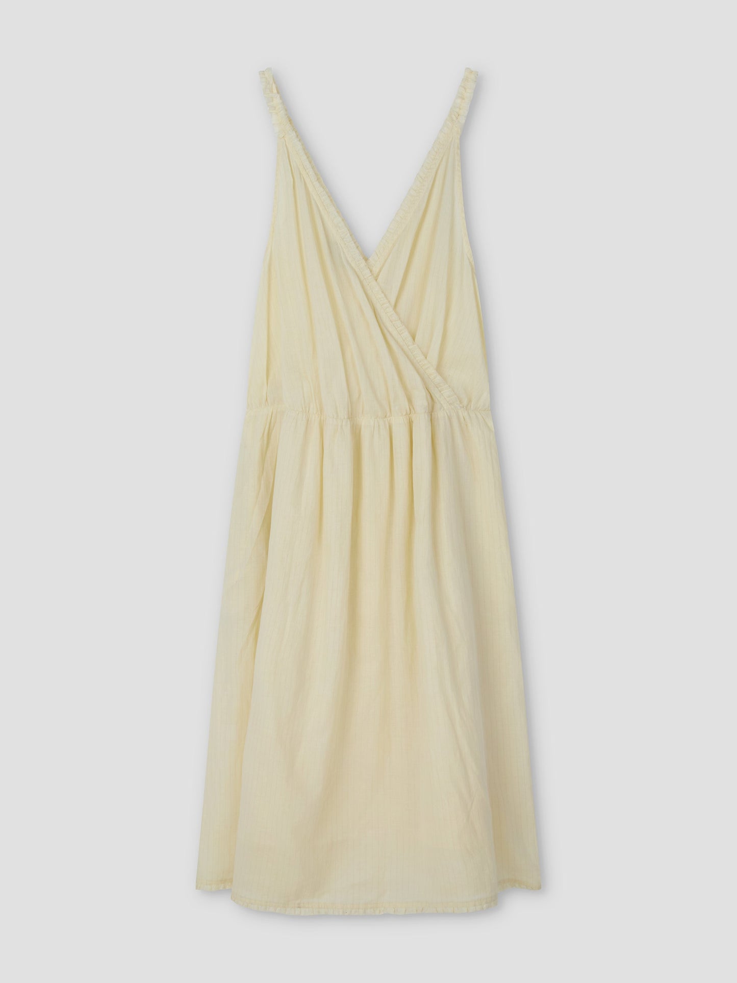 The Crossed Dress - Soft Yellow Stripe features a sleeveless design with a V-neck wrap-style bodice and gathered waist, shown on a plain light gray background. Inspired by Deiji Studios.
