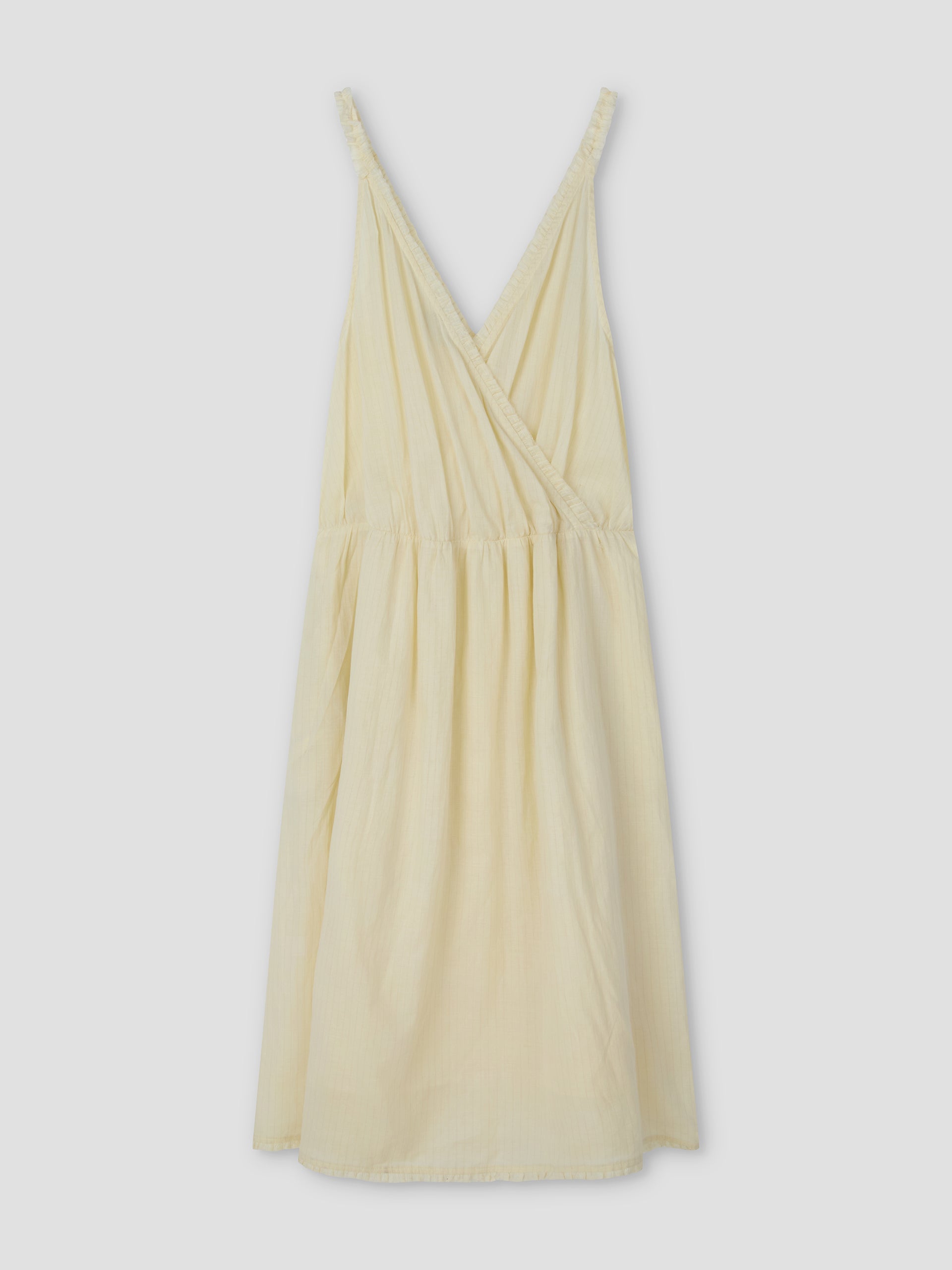 The Crossed Dress - Soft Yellow Stripe features a sleeveless design with a V-neck wrap-style bodice and gathered waist, shown on a plain light gray background. Inspired by Deiji Studios.