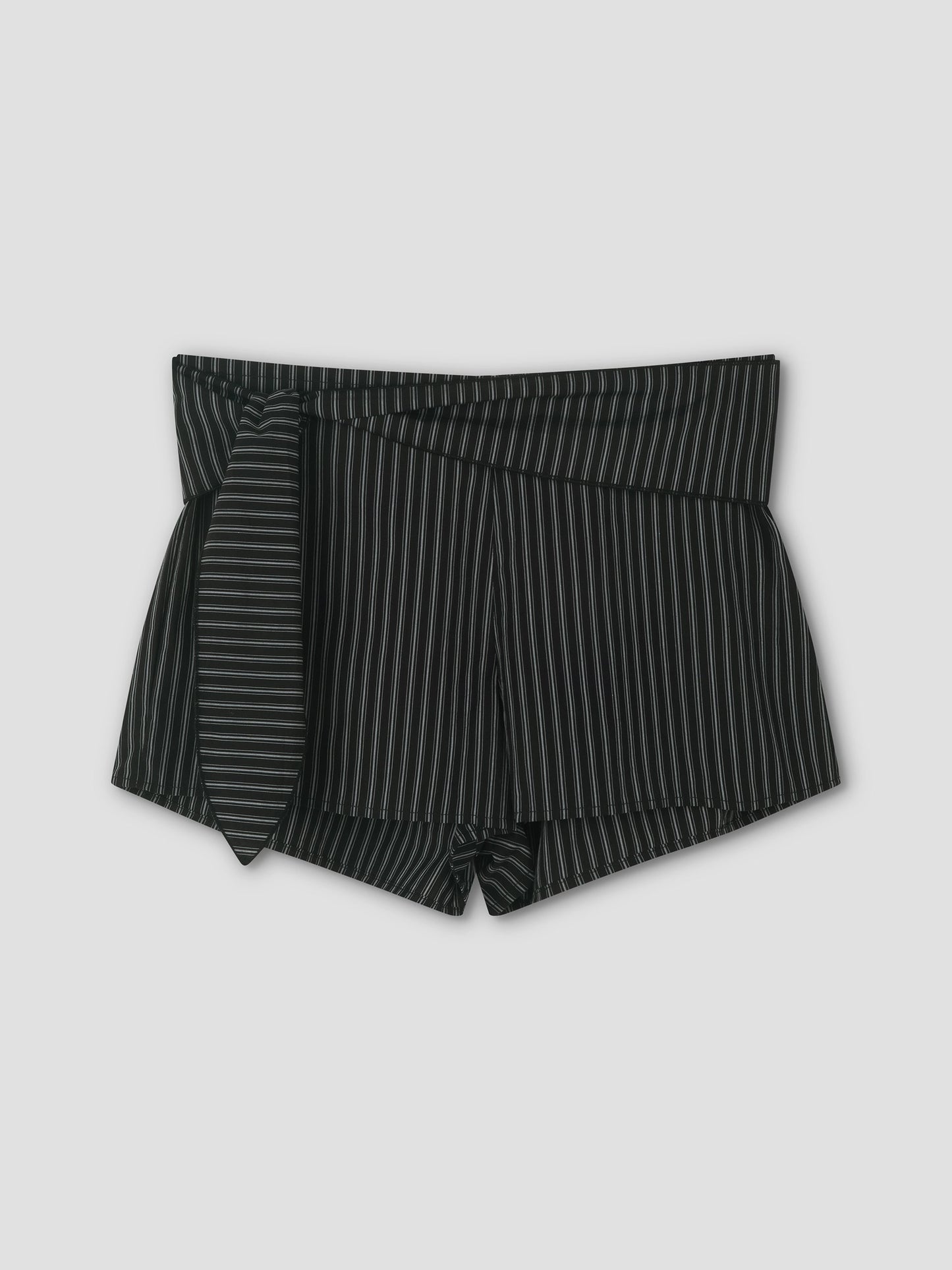 The Belted Short - Mono Stripe features black high-waisted mini shorts with thin white vertical pinstripes and a matching fabric belt tied on the left, shown against a plain light gray background.
