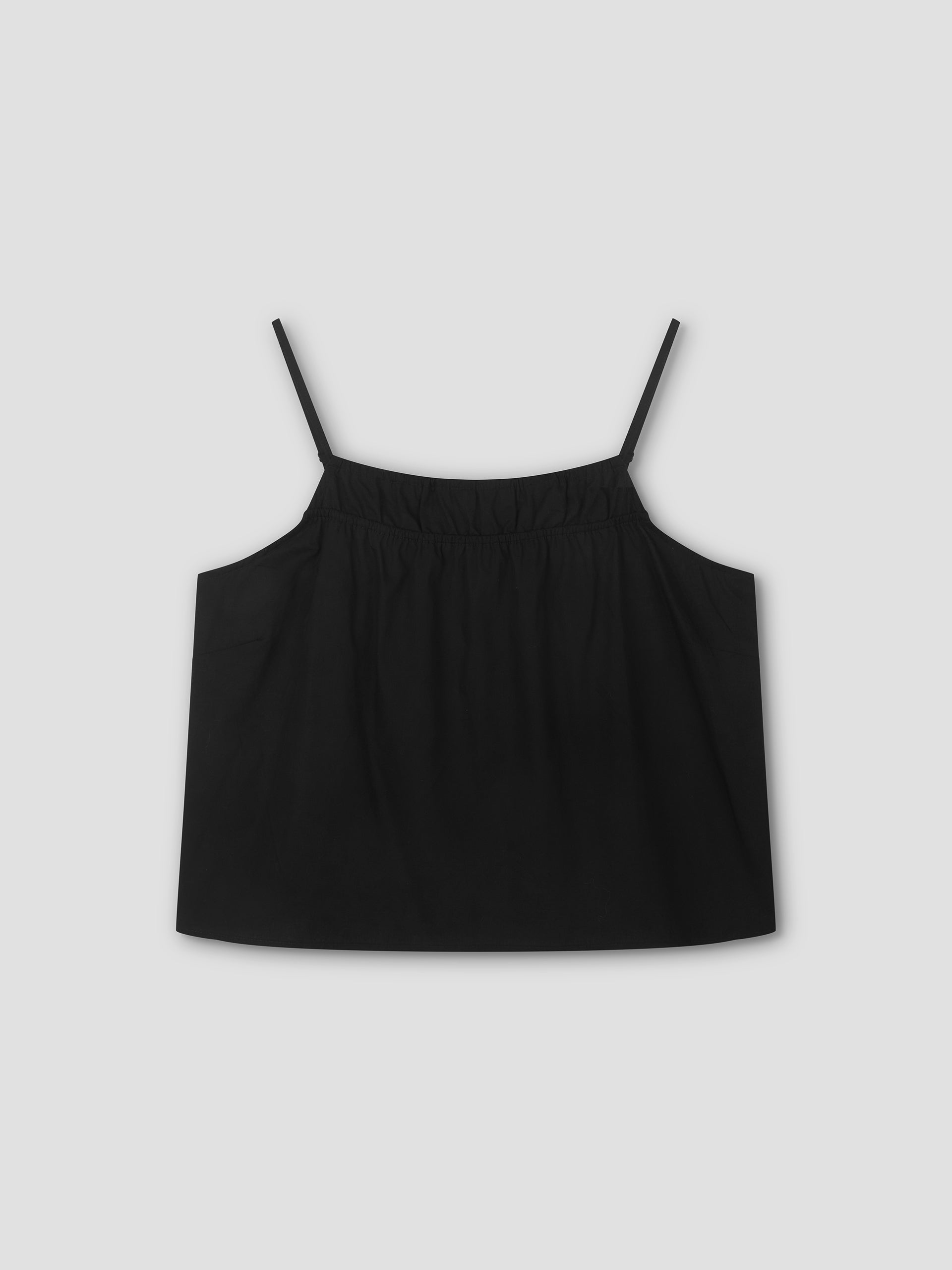 The Double Layer Top - Black by Deiji Studios features thin spaghetti straps and a gathered neckline in a relaxed fit, shown against a plain light gray background.