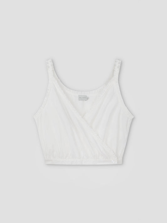 The Overlie Top - White is a sleeveless crop top with a V-neck wrap design, ruched straps, fitted waist, and elasticated hem, shown against a plain light gray background.