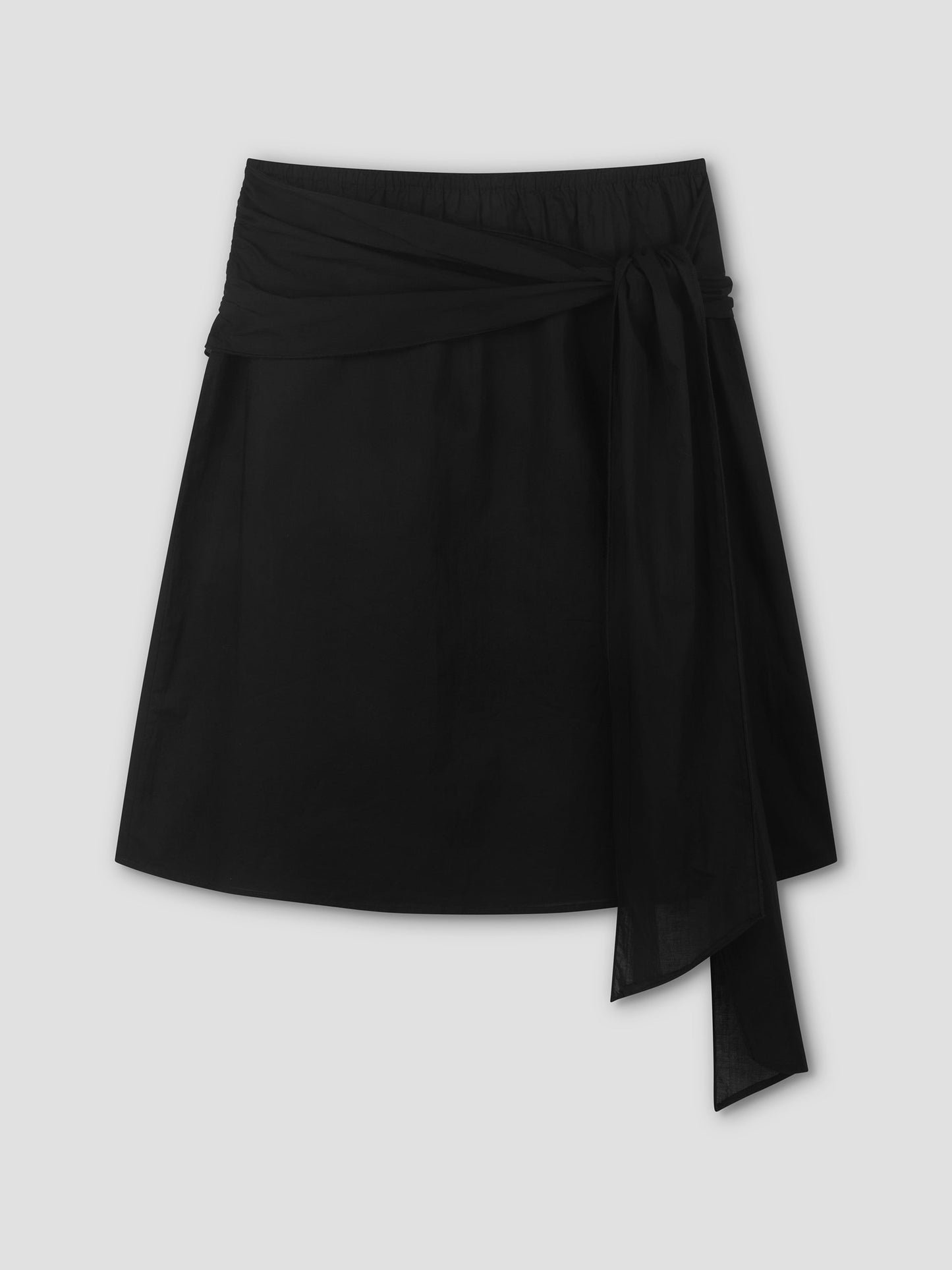 The Scarf Midi - Black by Deiji Studios is a black midi skirt with a wrap design and a wide, long sash tied in a bow at the waist, shown against a plain light gray background.