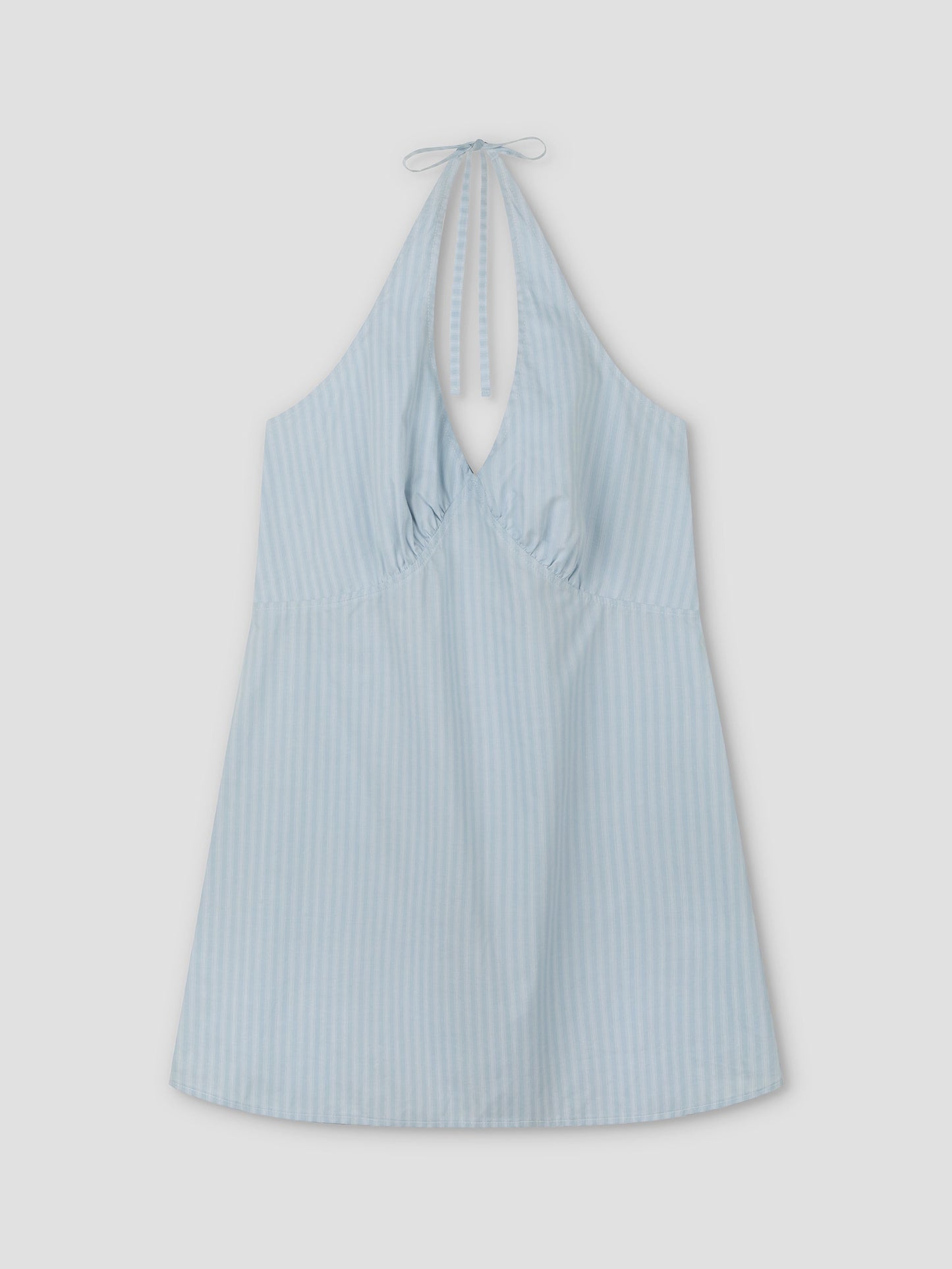 Cinched Halter Dress - Lake Blue Stripe from Deiji Studios, featuring light blue fabric with subtle vertical white stripes, a sleeveless design, gathered chest, and halter neck tie, shown laid flat on a white background.