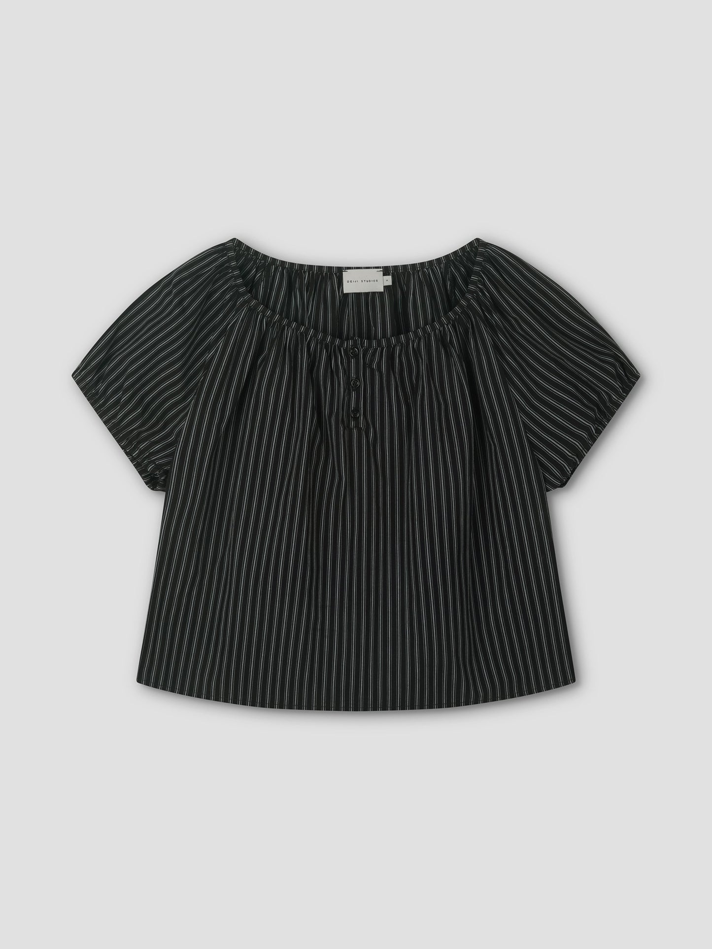 The Poplin T Shirt - Mono Stripe is a black short-sleeve blouse with white stripes, a loose fit, elastic gathered neckline, and center tie, styled like Deiji Studios. It’s displayed flat on a light gray background.