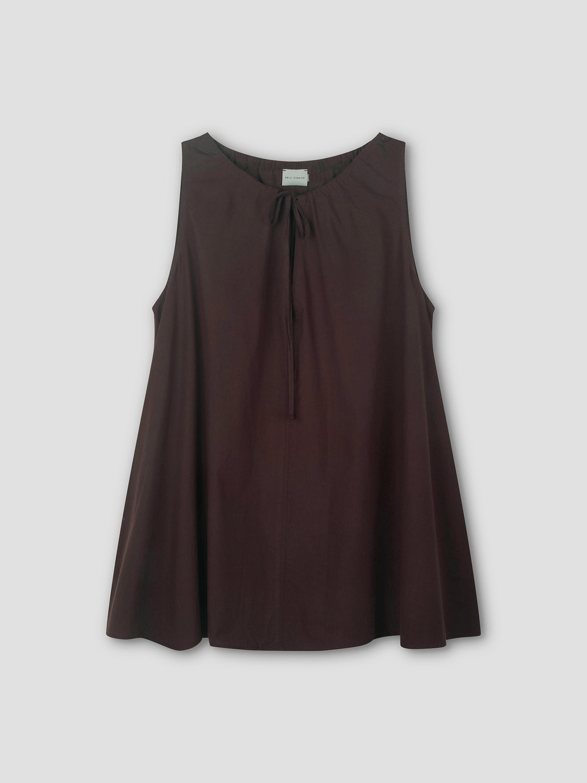 The Drawcord Dress in sepia is sleeveless and loose-fitting, with a round neckline and tie detail, featuring an A-line silhouette. Shown against a light grey background.