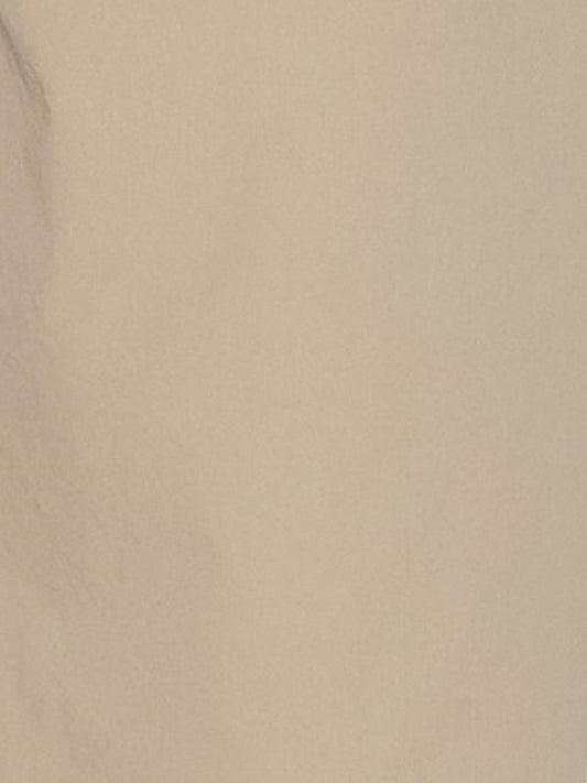 A close-up of a smooth beige surface with subtle shadows and texture, evoking the refined organic cotton featured in Deiji Studios Two Band Pant - Fawn.
