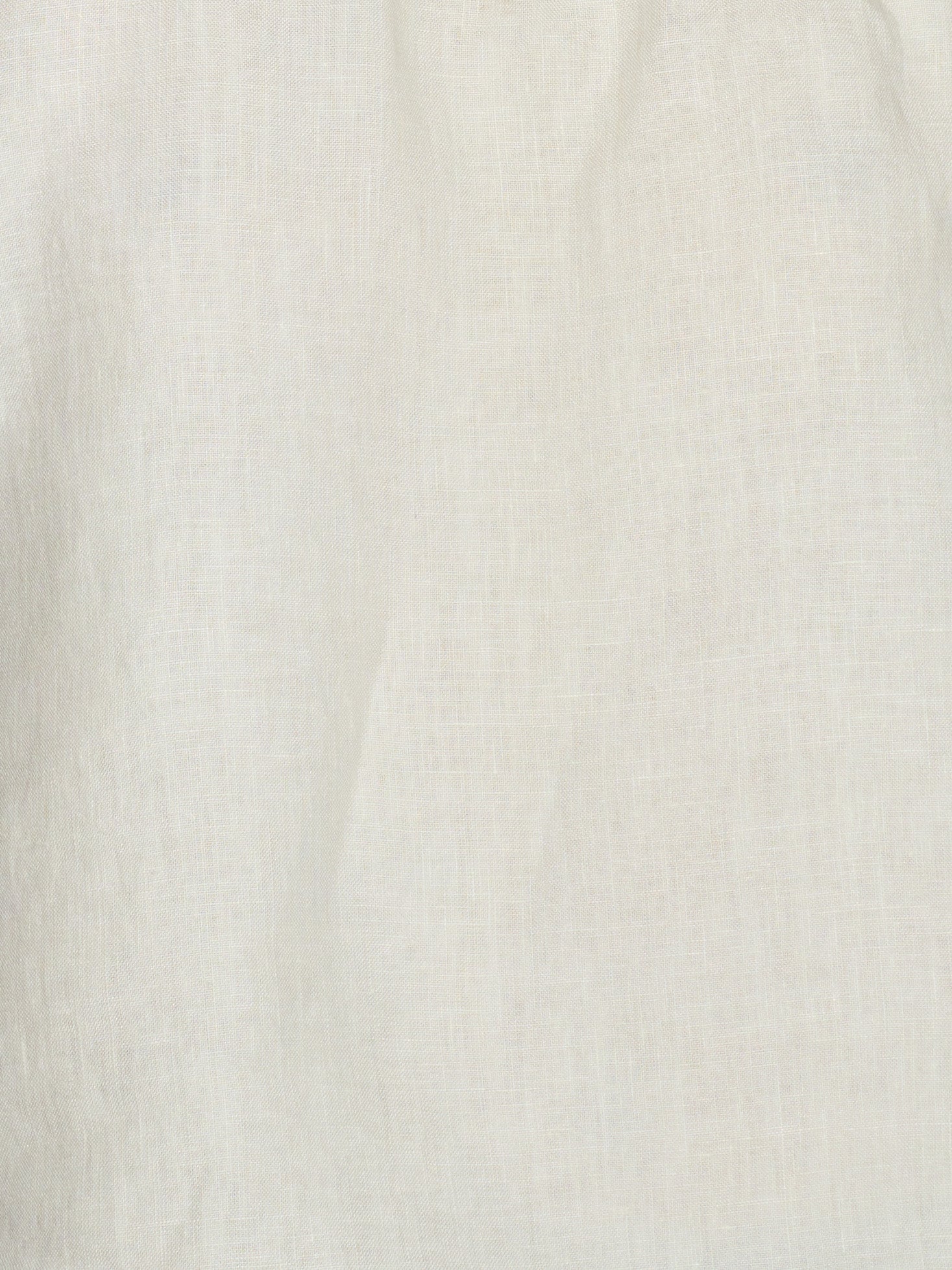 Close-up of a plain, light-colored French linen fabric with a subtle woven texture and soft folds, as used in the Linen Strap Dress - Pastel Pistachio. The material appears off-white or cream in color.