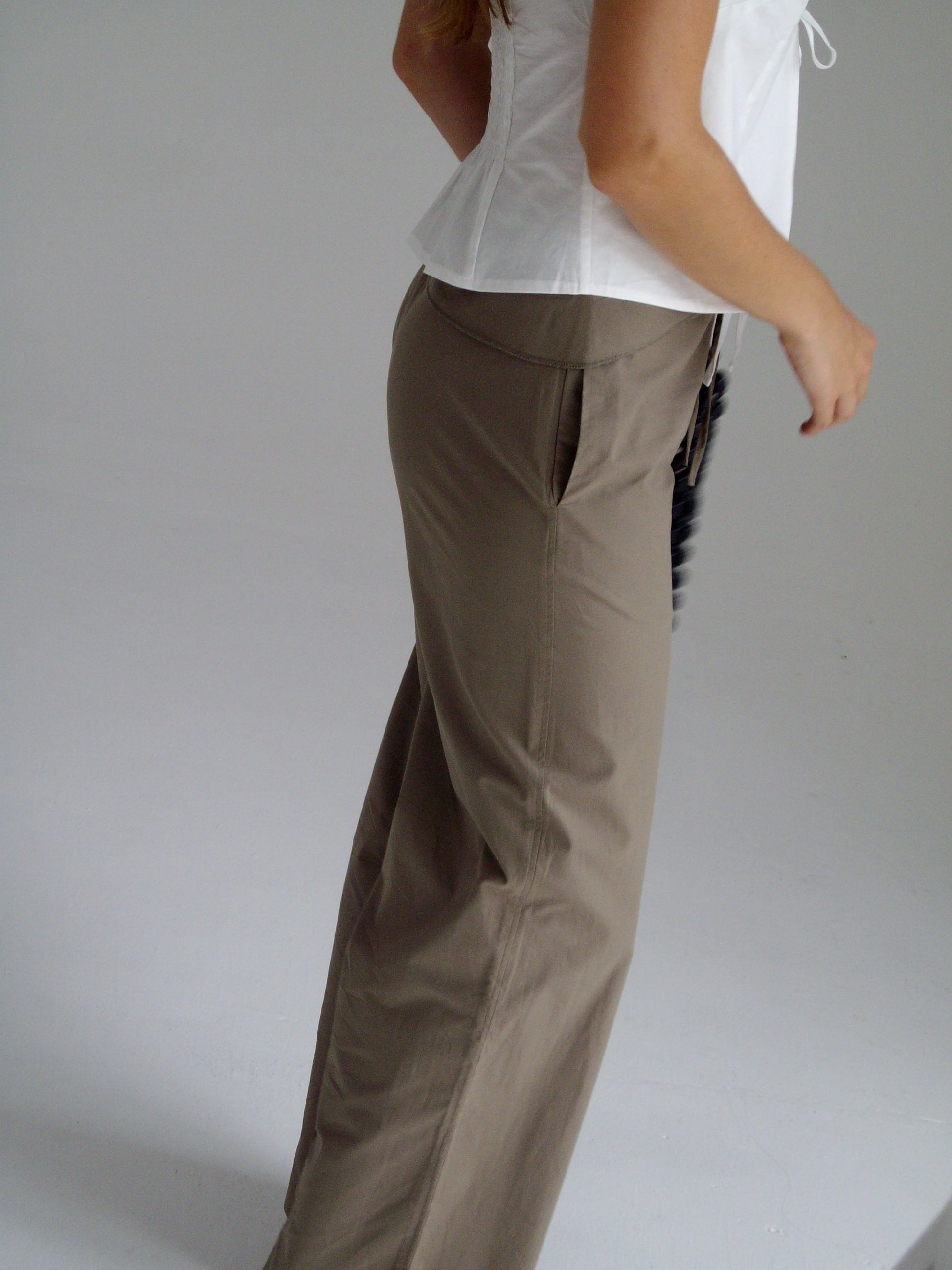 female model wears the belted pant by Deiji Studios in clay


mid-rise loose-leg pant with attached tie-front belt detail, babylock hem, and relaxed fit. features concealed zip closure and side pockets


made from 100% organic cotton

paired with a white cotton top