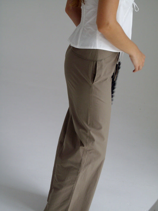 female model wears the belted pant by Deiji Studios in clay


mid-rise loose-leg pant with attached tie-front belt detail, babylock hem, and relaxed fit. features concealed zip closure and side pockets


made from 100% organic cotton

paired with a white cotton top