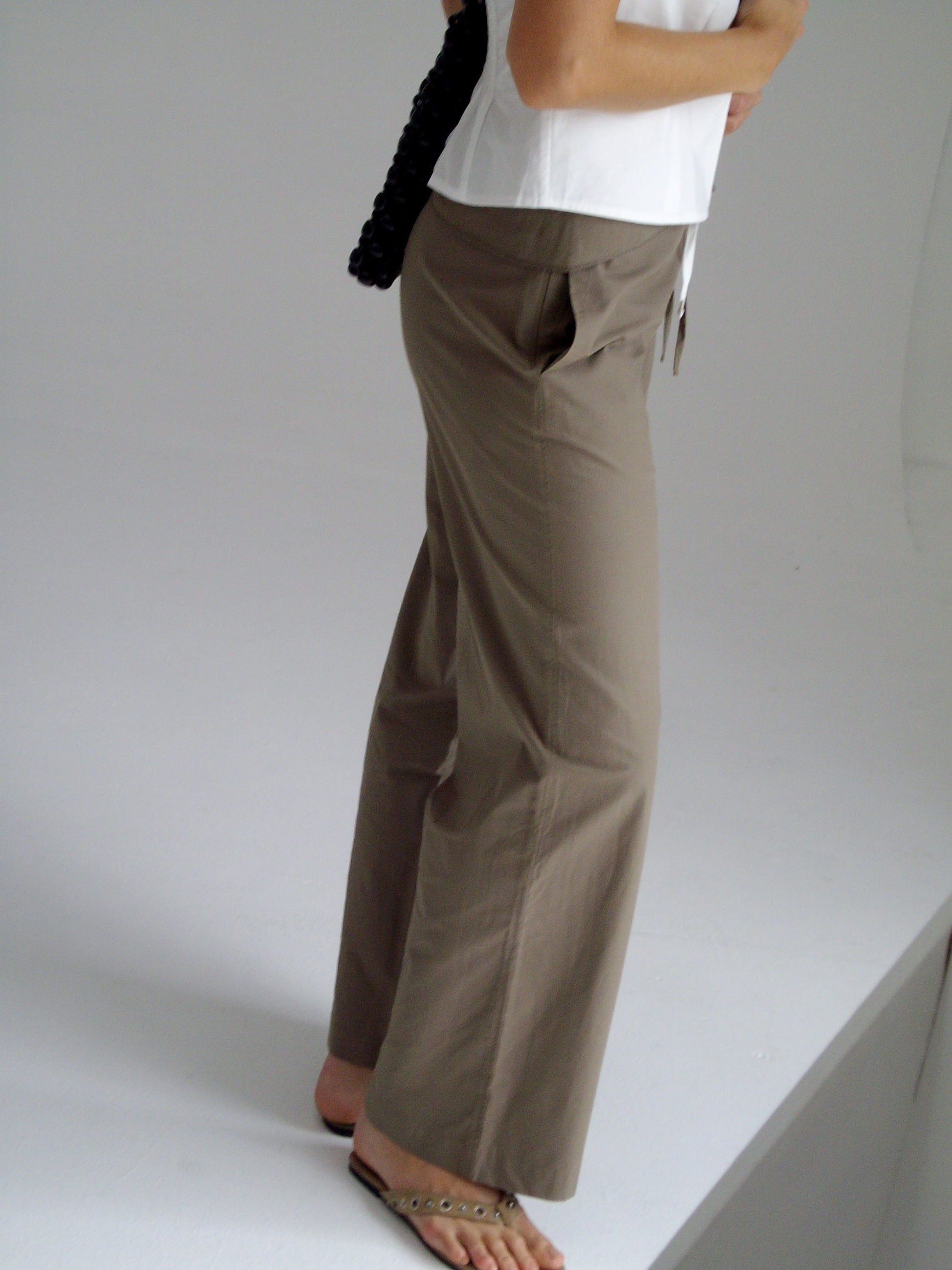 female model wears the belted pant by Deiji Studios in clay


mid-rise loose-leg pant with attached tie-front belt detail, babylock hem, and relaxed fit. features concealed zip closure and side pockets


made from 100% organic cotton

paired with a white cotton top