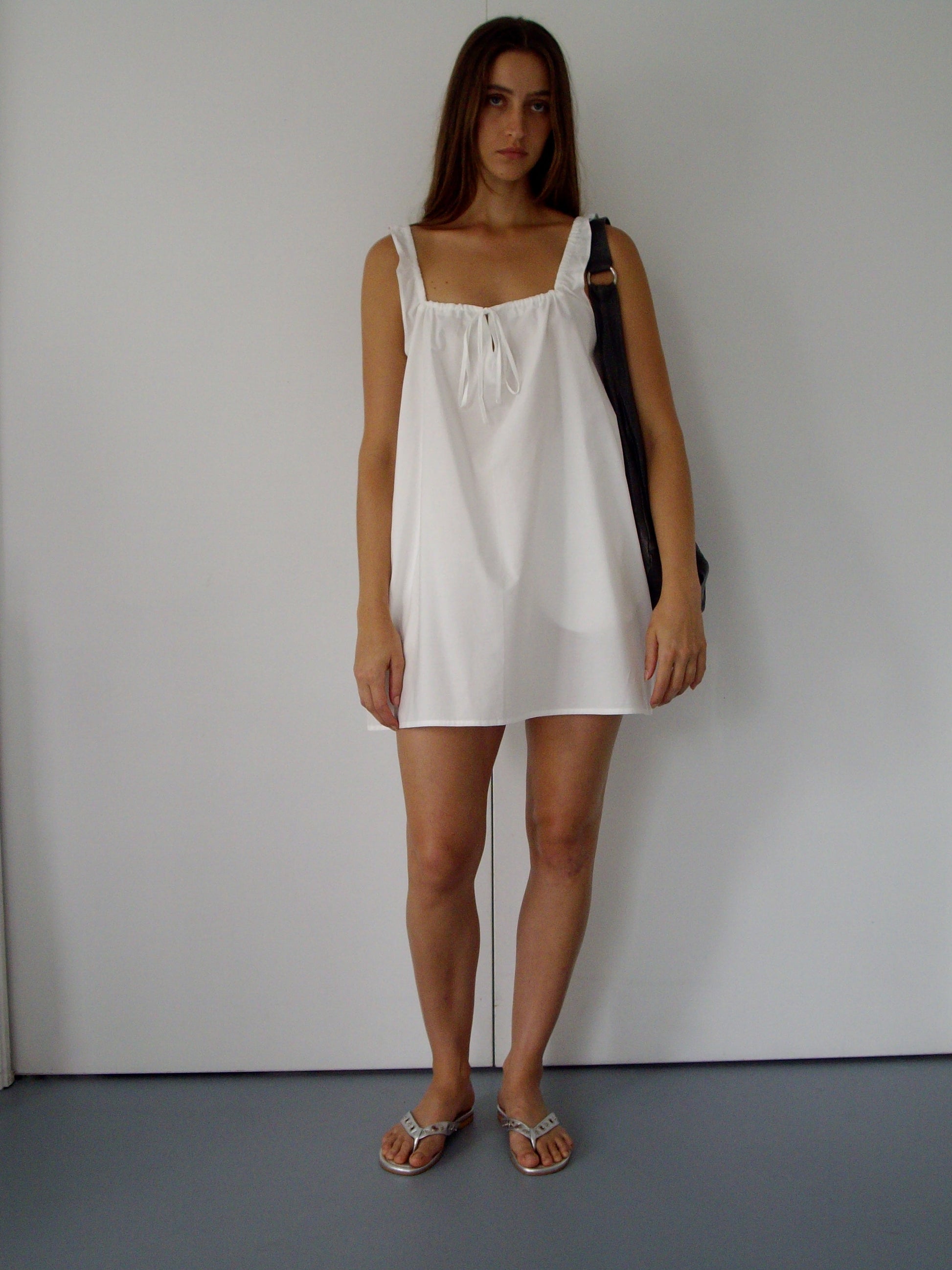 female model wears the bow dress in white exclusive to Deiji Studios

a crisp and lightweight mini-length dress features a flattering gathered square neckline with keyhole and tie front feature and side seam pockets


made from 100% GOTS certified organic cotton poplin