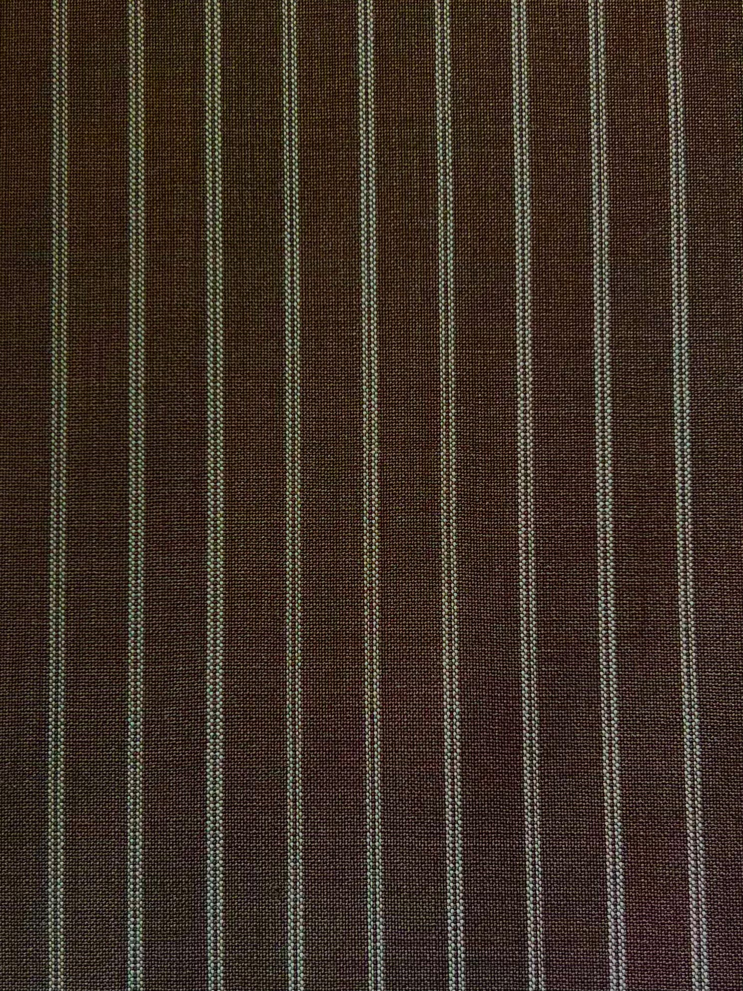 The Folded Wool Pant - Sable Stripe by 0 features evenly spaced white pinstripes on textured RWS wool, offering a timeless, slightly coarse look.