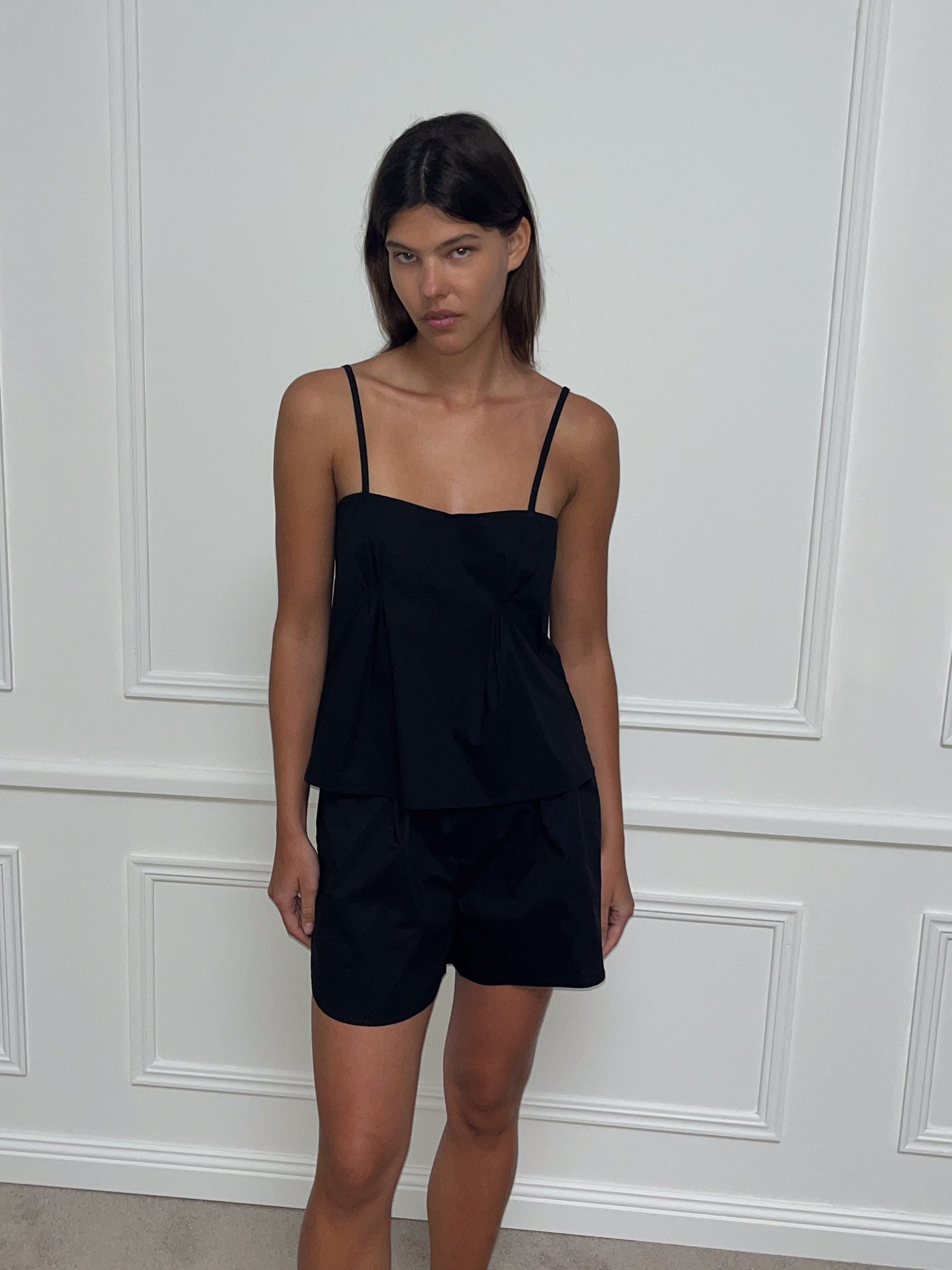 Female model wearing Pleat Set - Black by Deiji Studios against plain background